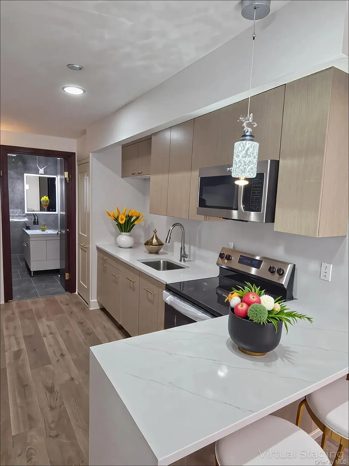 Kitchen with appliances with stainless steel finishes, a breakfast bar area, light wood-type flooring, a peninsula, and recessed lighting Kitchen with appliances with stainless steel finishes, a breakfast bar area, light wood-type flooring, a peninsula, and recessed lighting