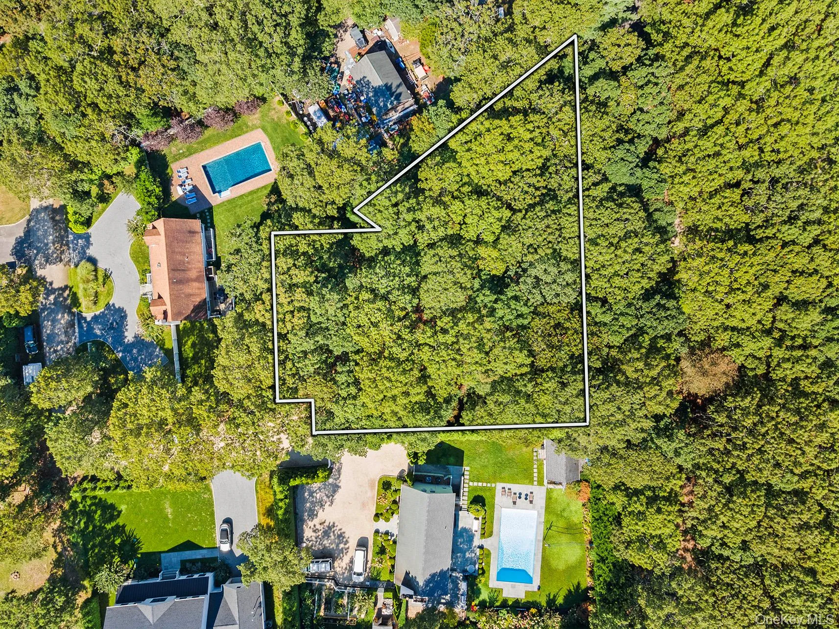 Aerial view of property's location with a pool and property parcel outlined Aerial view of property's location with a pool and property parcel outlined