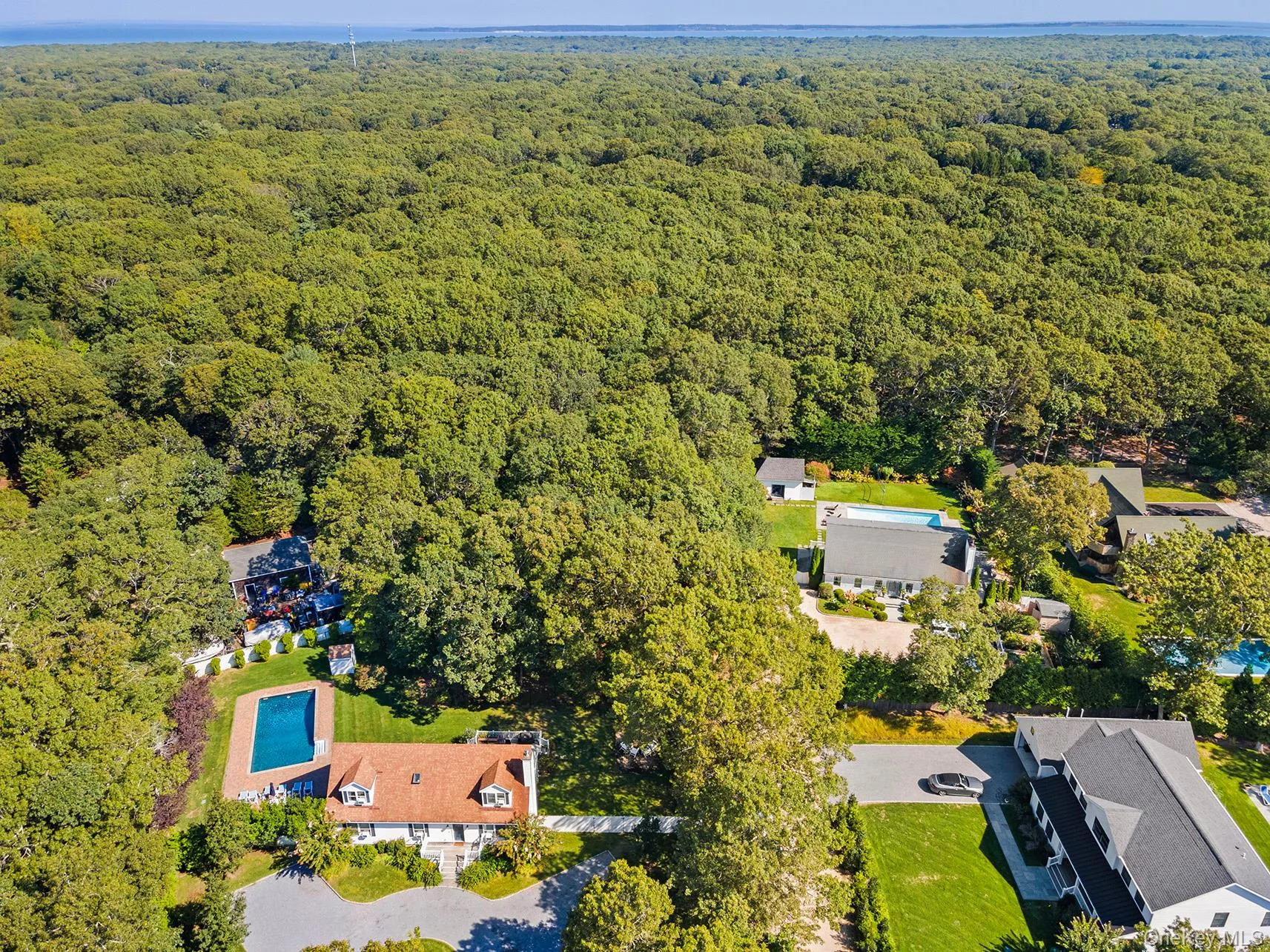 Aerial view of property and surrounding area with a forest Aerial view of property and surrounding area with a forest