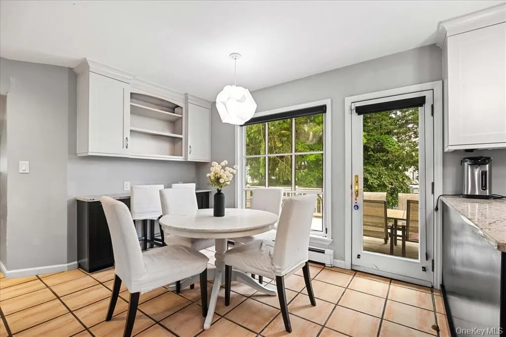 Dining room featuring light tile patterned floors and baseboard heating Dining room featuring light tile patterned floors and baseboard heating