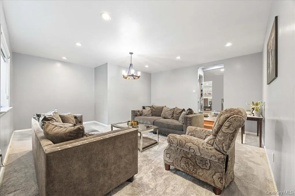 Living area with carpet flooring, recessed lighting, and a chandelier Living area with carpet flooring, recessed lighting, and a chandelier