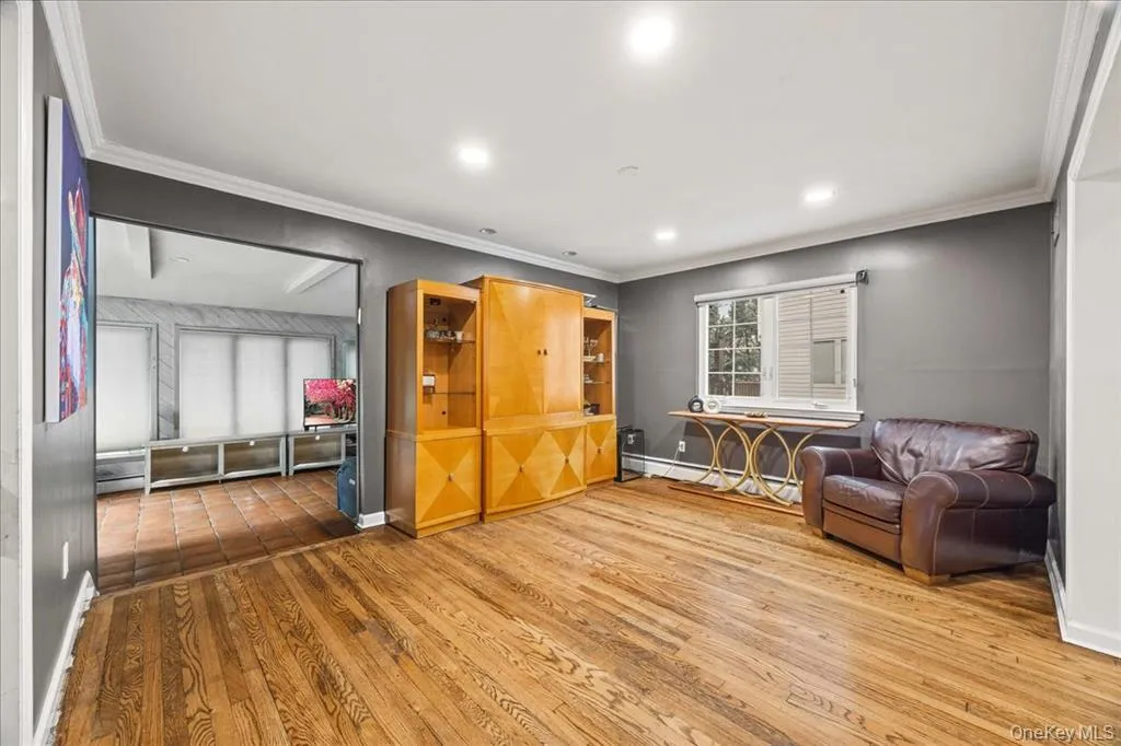 Sitting room featuring ornamental molding, wood finished floors, recessed lighting, and a baseboard heating unit Sitting room featuring ornamental molding, wood finished floors, recessed lighting, and a baseboard heating unit
