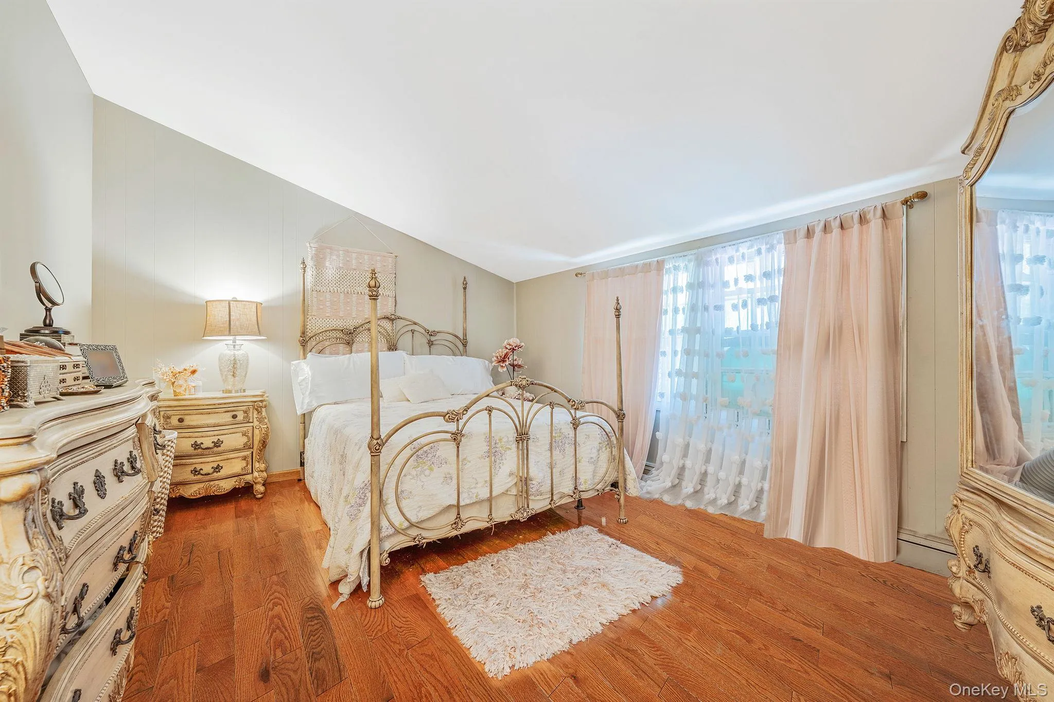 Bedroom with multiple windows, wood finished floors, and lofted ceiling Bedroom with multiple windows, wood finished floors, and lofted ceiling