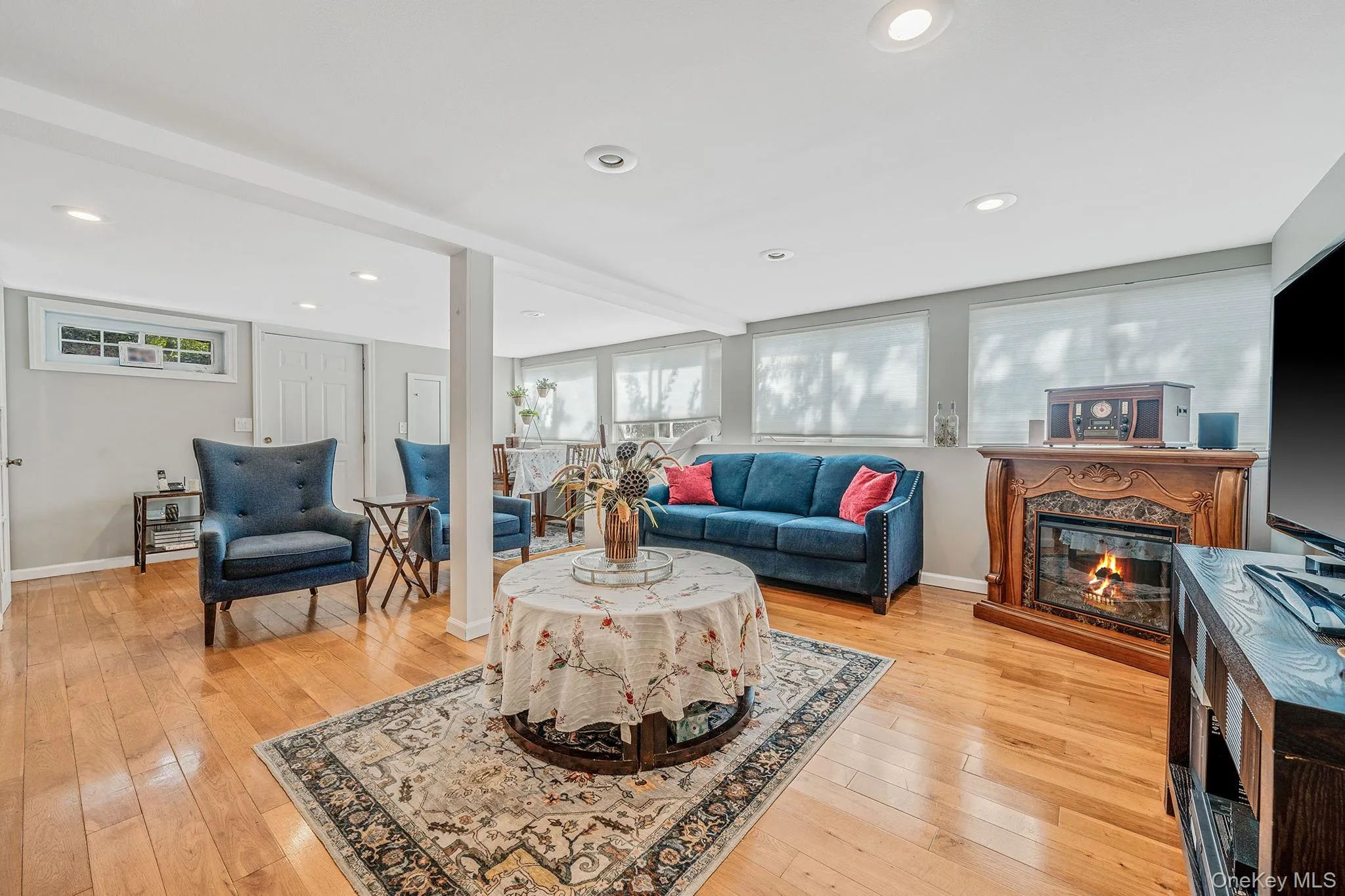 Living room featuring a fireplace, recessed lighting, and light wood finished floors Living room featuring a fireplace, recessed lighting, and light wood finished floors