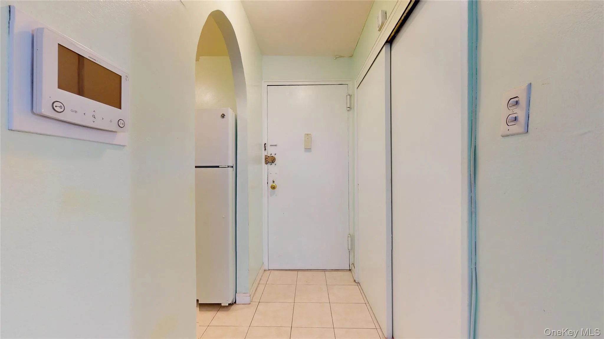Hallway featuring light tile patterned floors and arched walkways Hallway featuring light tile patterned floors and arched walkways