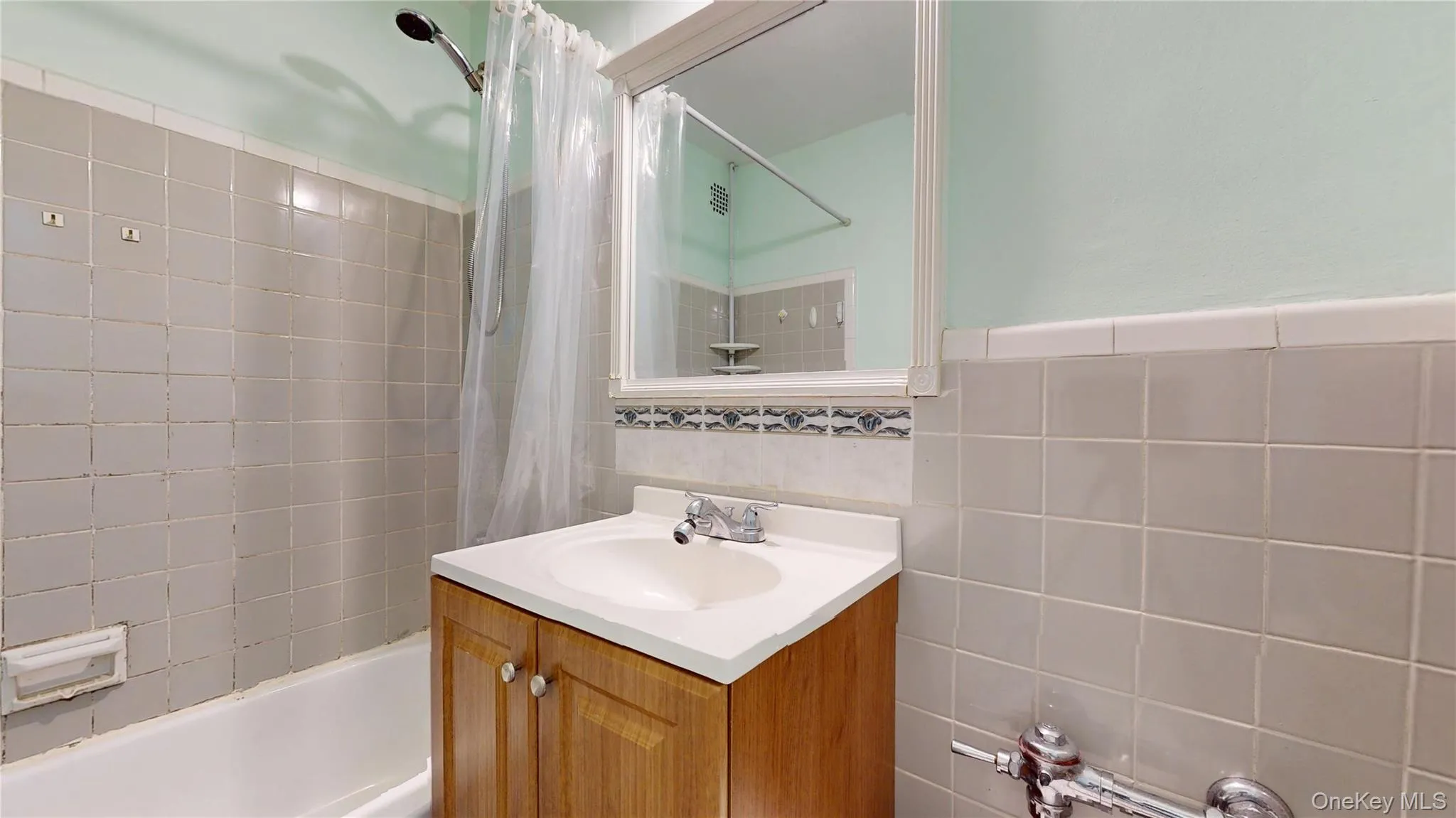 Full bath featuring shower / bathtub combination with curtain, tile walls, and vanity Full bath featuring shower / bathtub combination with curtain, tile walls, and vanity