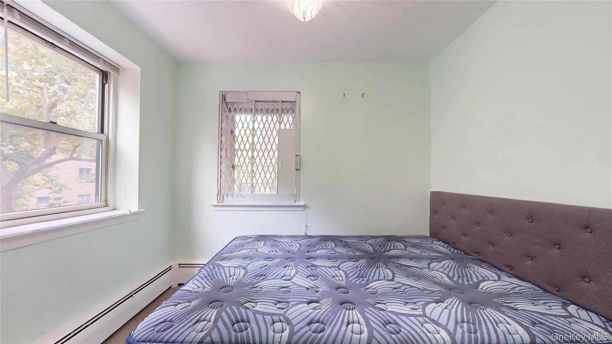 Bedroom with baseboard heating and multiple windows Bedroom with baseboard heating and multiple windows