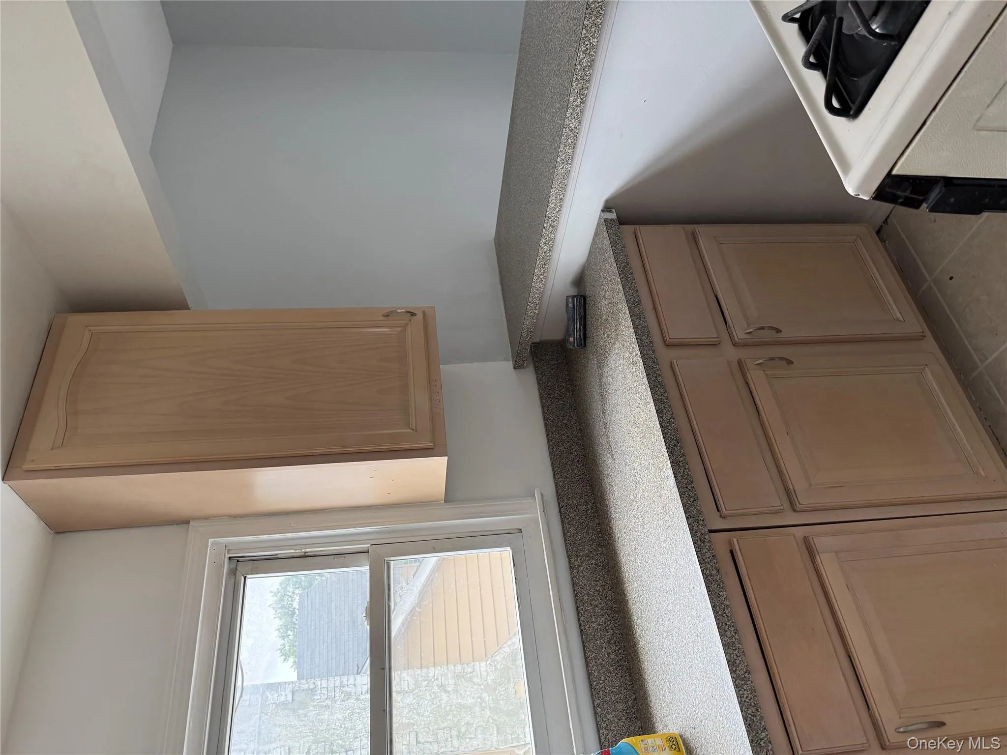 Kitchen featuring stove, light tile patterned floors, and light brown cabinetry Kitchen featuring stove, light tile patterned floors, and light brown cabinetry