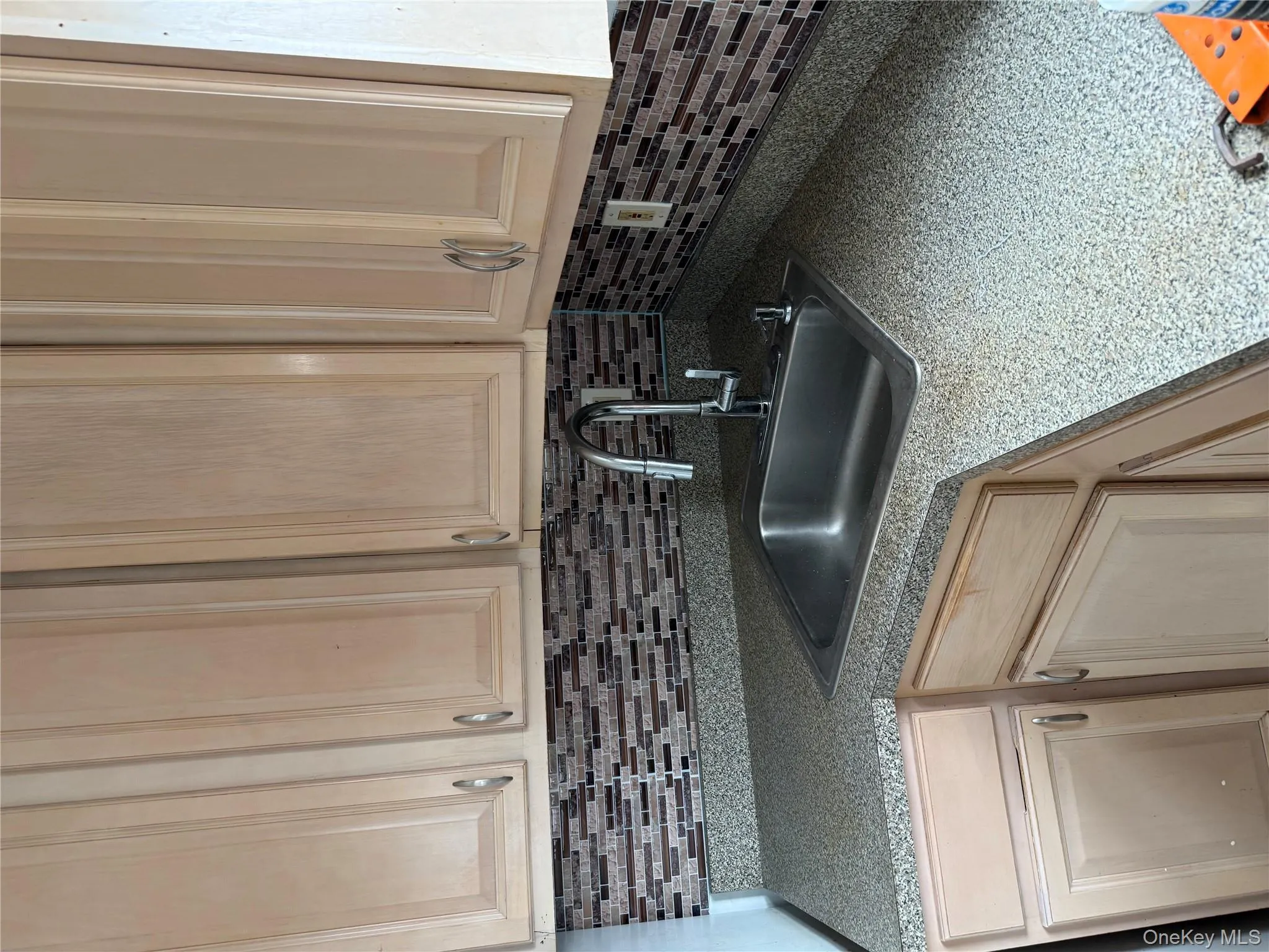 Kitchen featuring light brown cabinetry and decorative backsplash Kitchen featuring light brown cabinetry and decorative backsplash