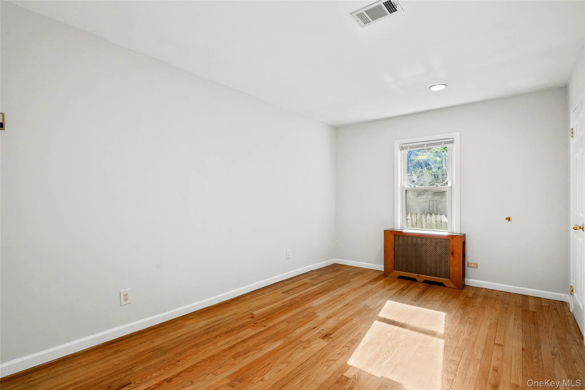 Unfurnished room with radiator, light wood-style flooring, and recessed lighting Unfurnished room with radiator, light wood-style flooring, and recessed lighting