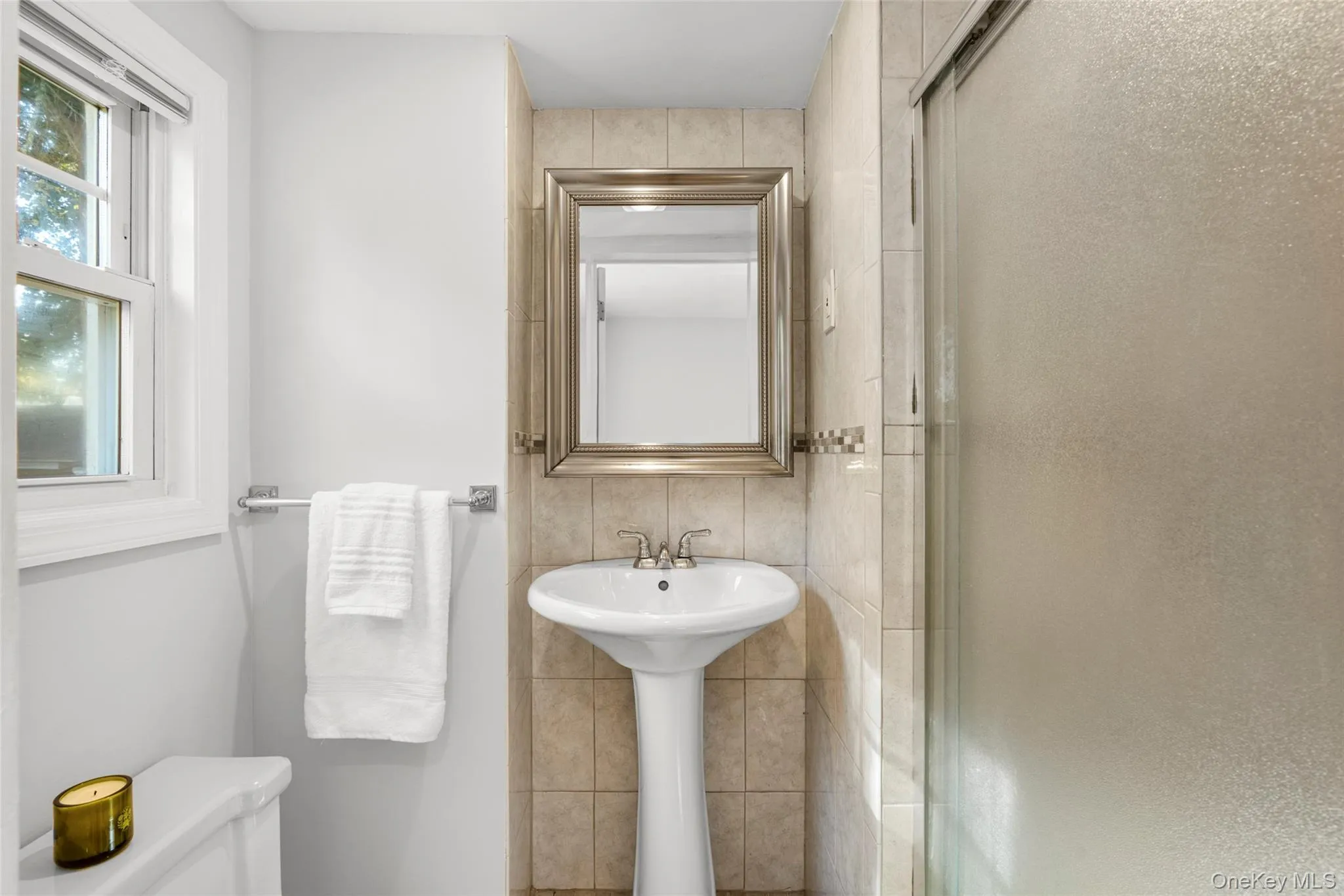 Full bath featuring tile walls, a shower stall, and tasteful backsplash Full bath featuring tile walls, a shower stall, and tasteful backsplash