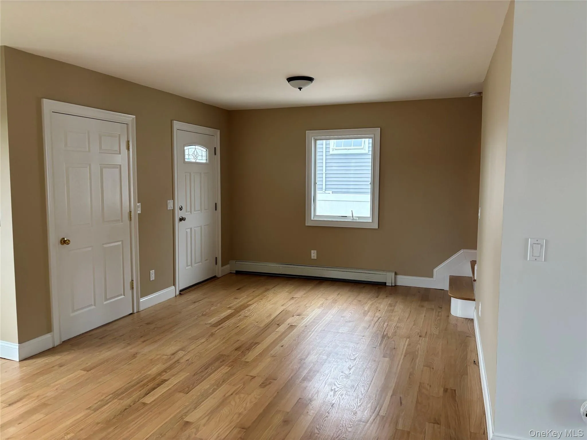 Entryway with light wood finished floors and baseboard heating Entryway with light wood finished floors and baseboard heating