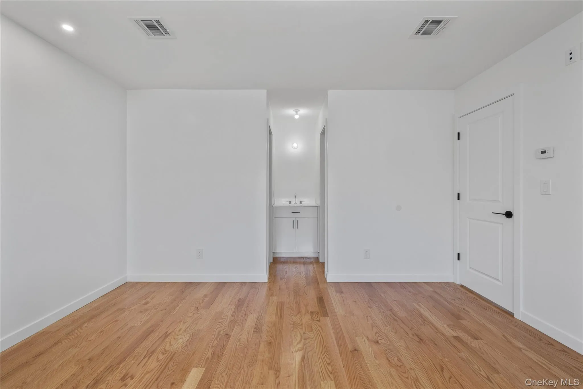 Empty room featuring baseboards, visible vents, and light wood-style flooring Empty room featuring baseboards, visible vents, and light wood-style flooring