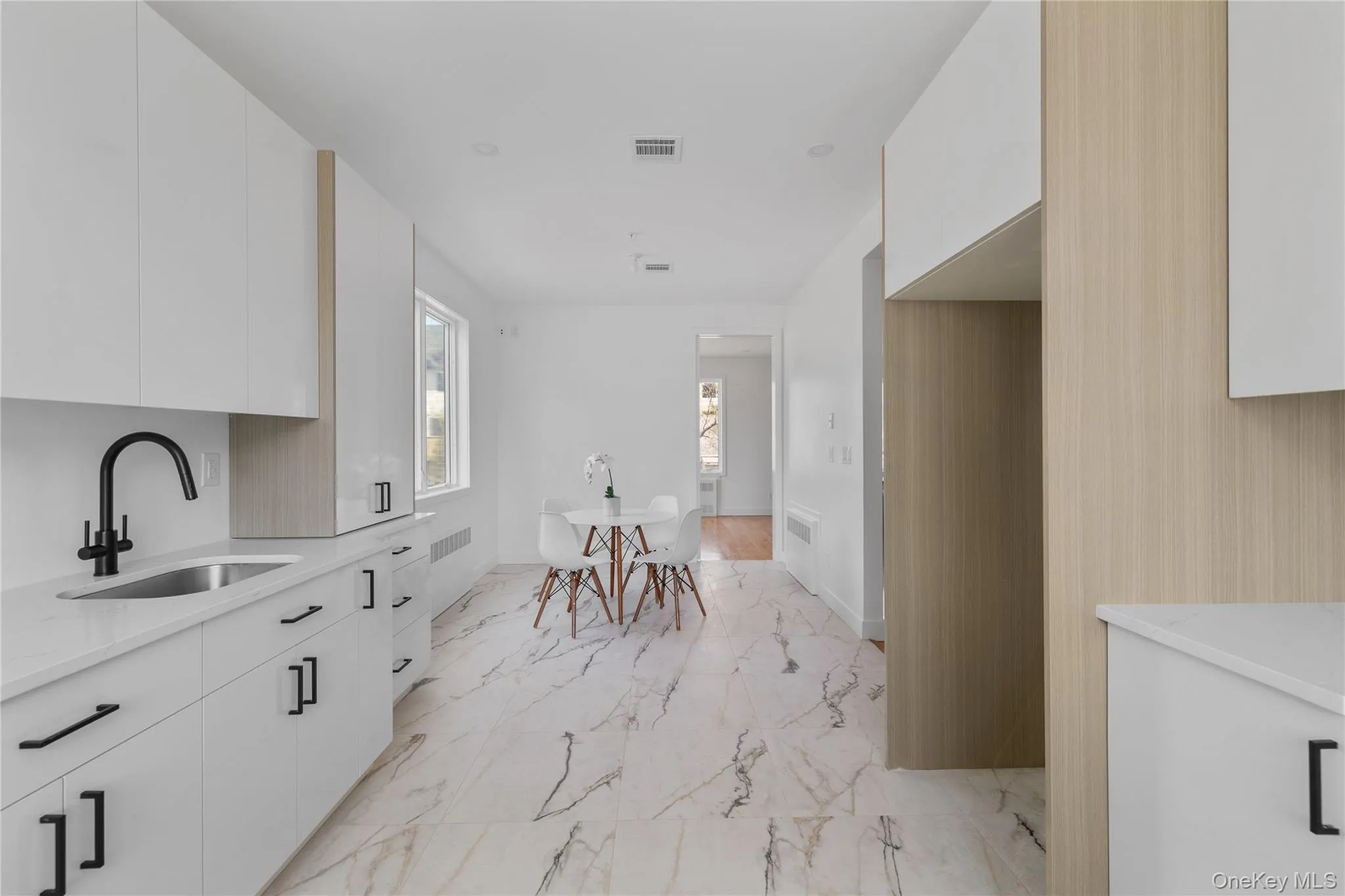 Kitchen with a sink, visible vents, white cabinetry, modern cabinets, and marble finish floor Kitchen with a sink, visible vents, white cabinetry, modern cabinets, and marble finish floor