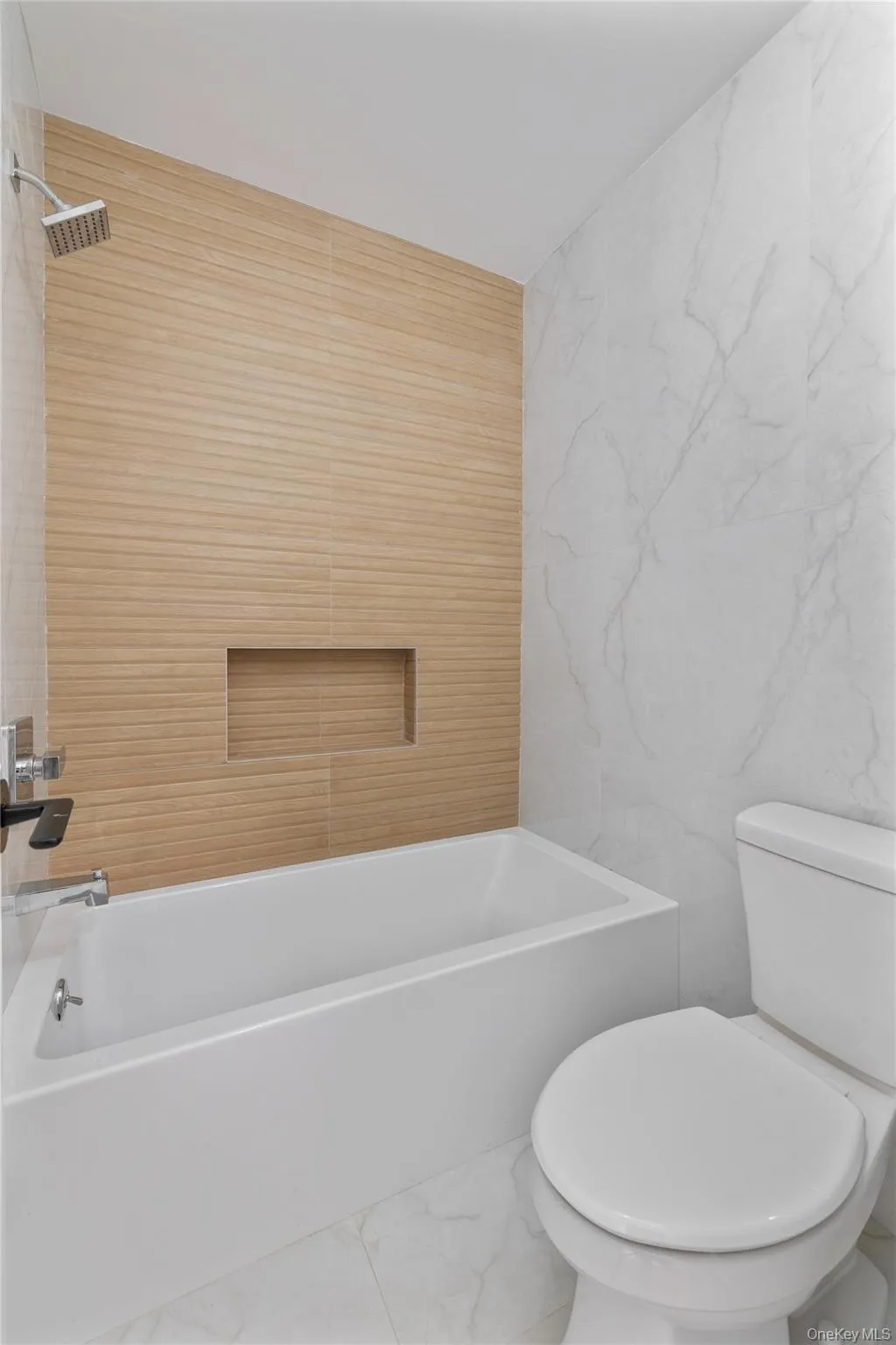 Bathroom with marble finish floor, tile walls, and toilet Bathroom with marble finish floor, tile walls, and toilet