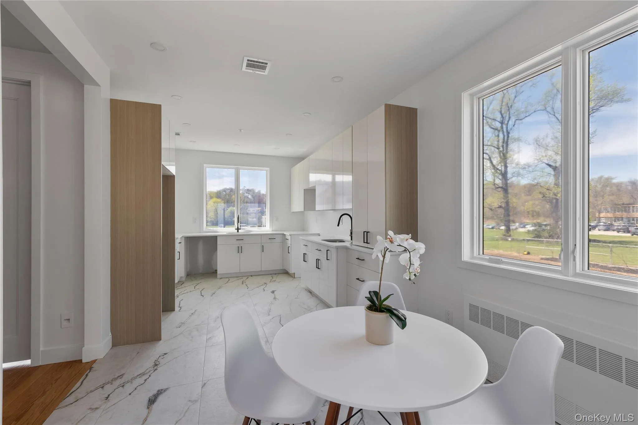 Dining space featuring marble finish floor, baseboards, radiator heating unit, and visible vents Dining space featuring marble finish floor, baseboards, radiator heating unit, and visible vents