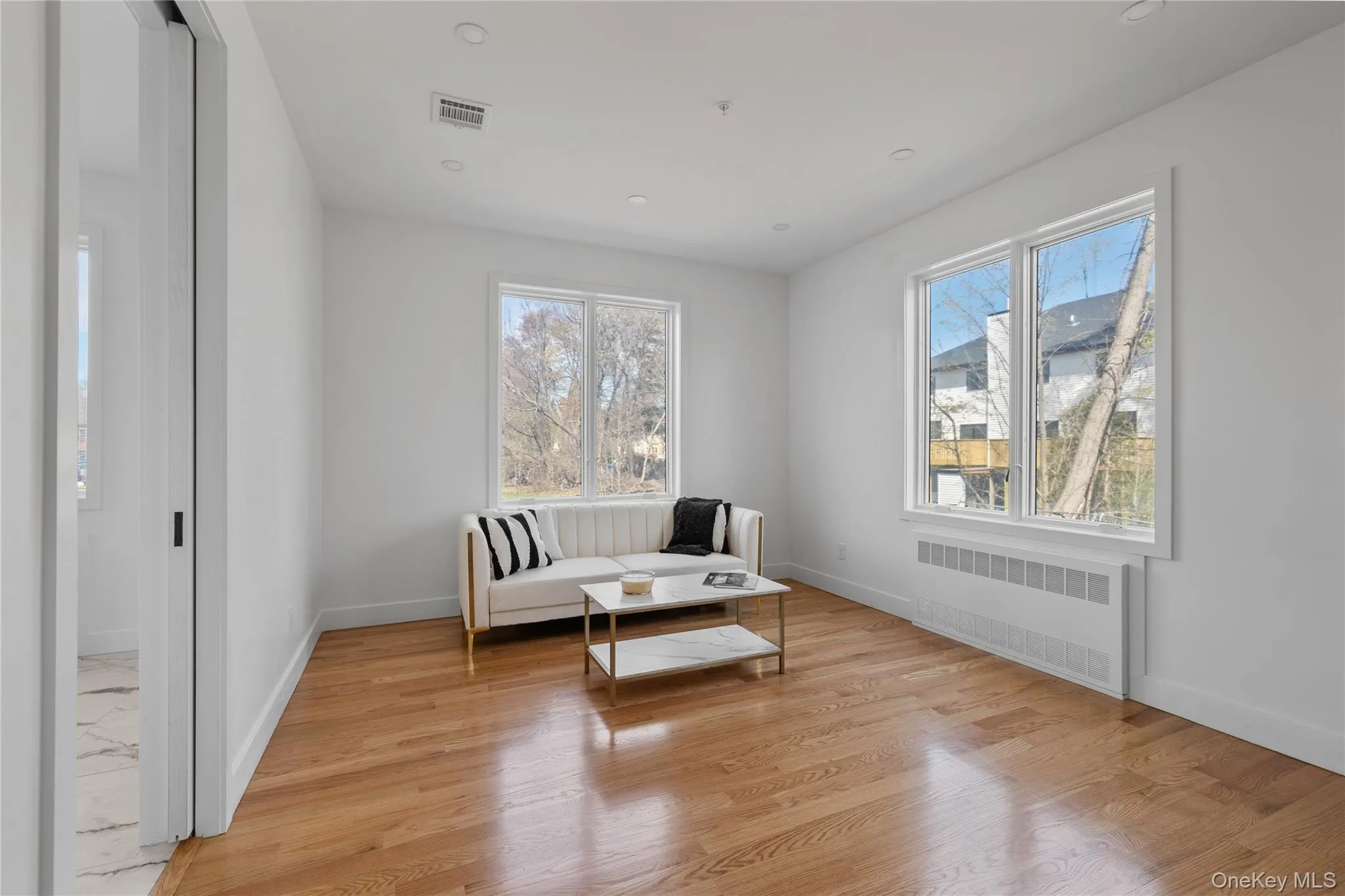 Sitting room featuring light wood-type flooring, baseboards, and radiator Sitting room featuring light wood-type flooring, baseboards, and radiator