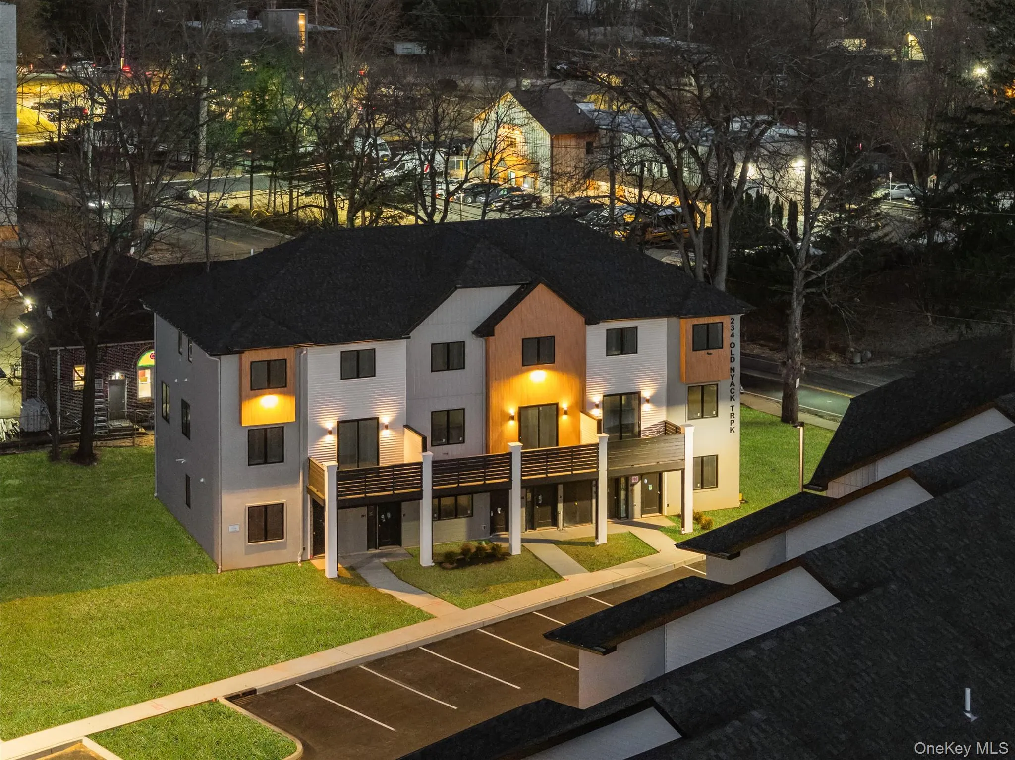 Back of property featuring a lawn and a shingled roof Back of property featuring a lawn and a shingled roof