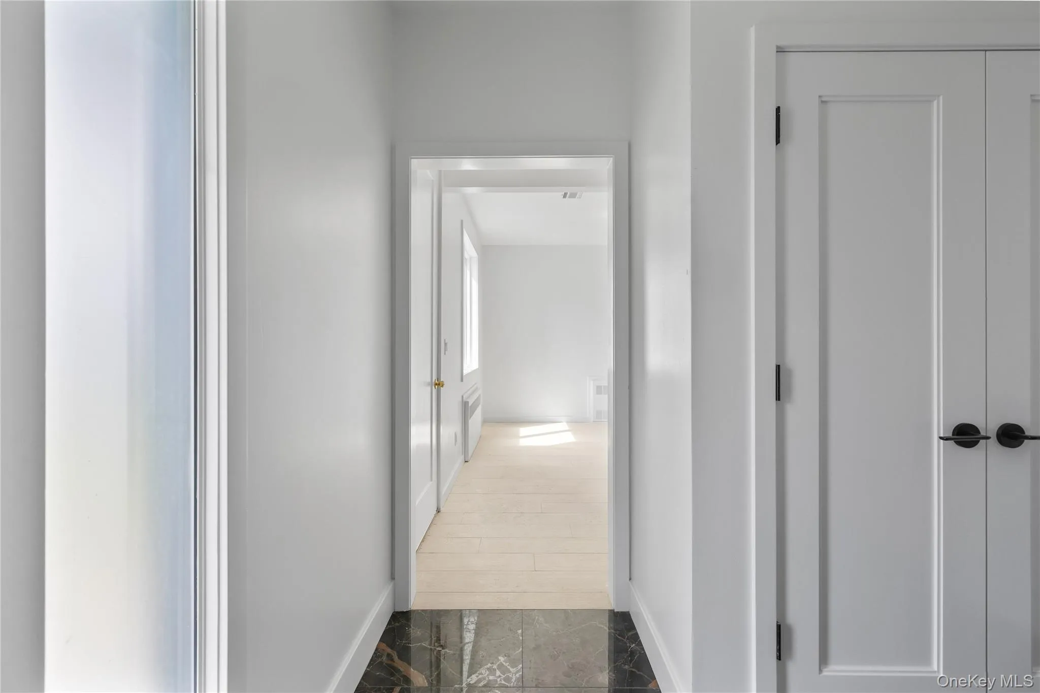 Hallway with marble finish floor and baseboards Hallway with marble finish floor and baseboards