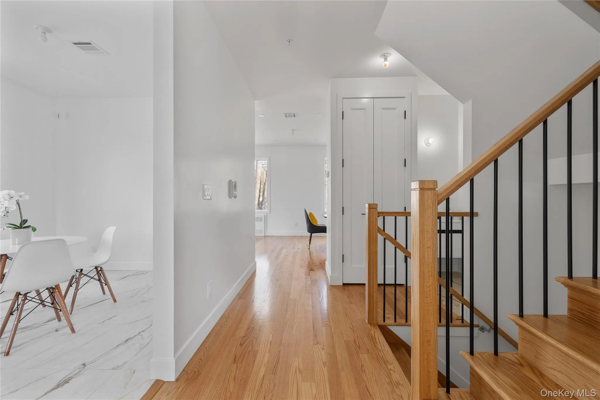Hall featuring light wood finished floors, baseboards, visible vents, and stairway Hall featuring light wood finished floors, baseboards, visible vents, and stairway