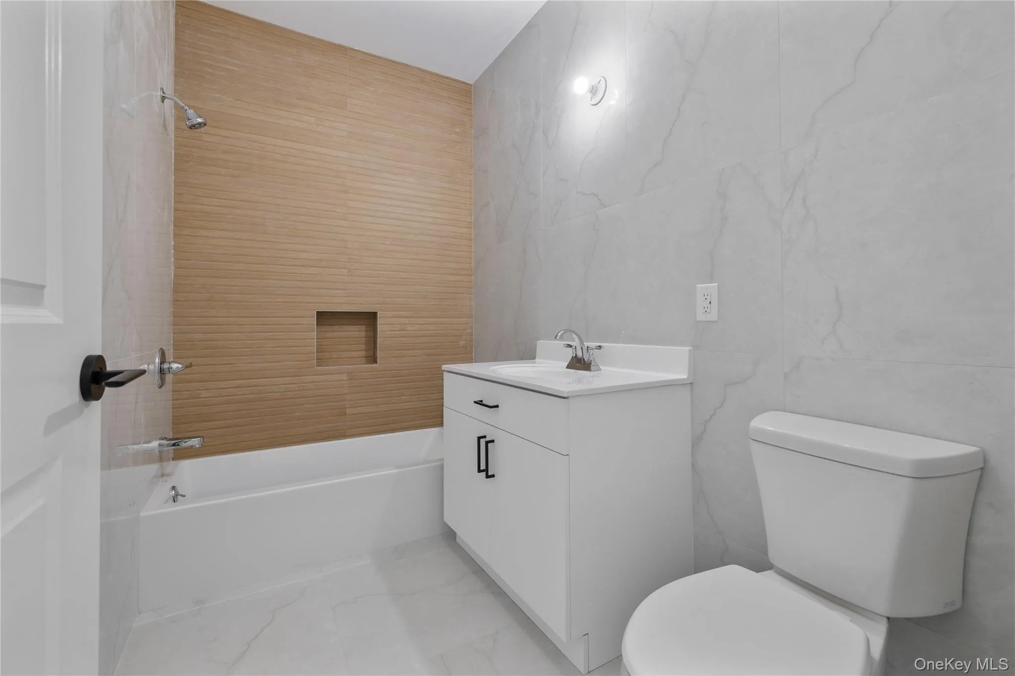 Full bath with marble finish floor, toilet, vanity, and tile walls Full bath with marble finish floor, toilet, vanity, and tile walls