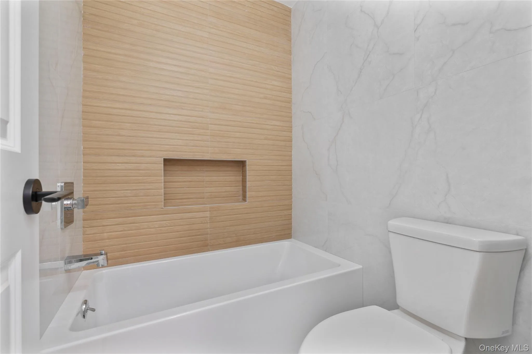 Full bath with tile walls, a tub, and toilet Full bath with tile walls, a tub, and toilet