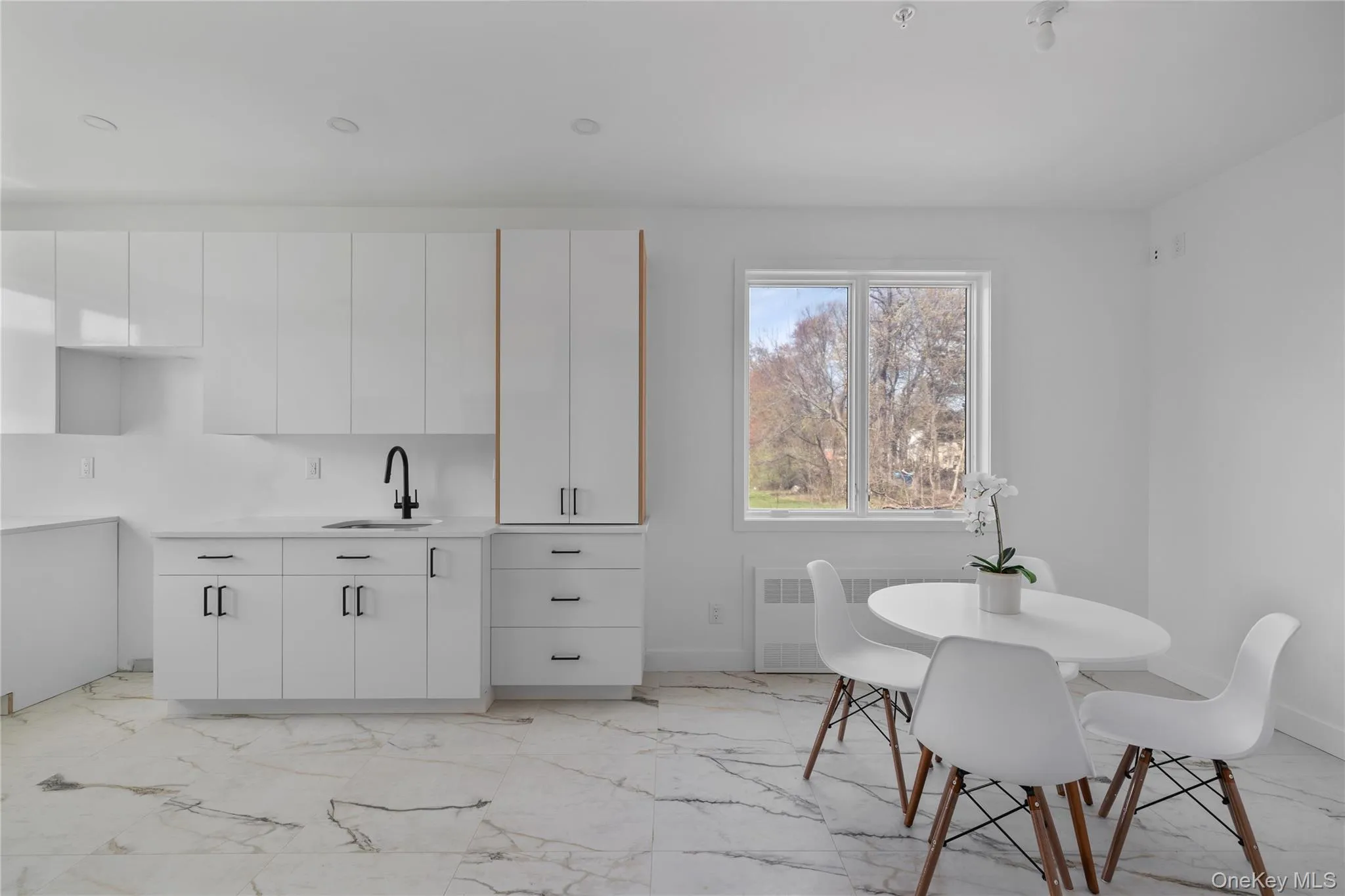 Dining room featuring radiator heating unit, marble finish floor, and baseboards Dining room featuring radiator heating unit, marble finish floor, and baseboards