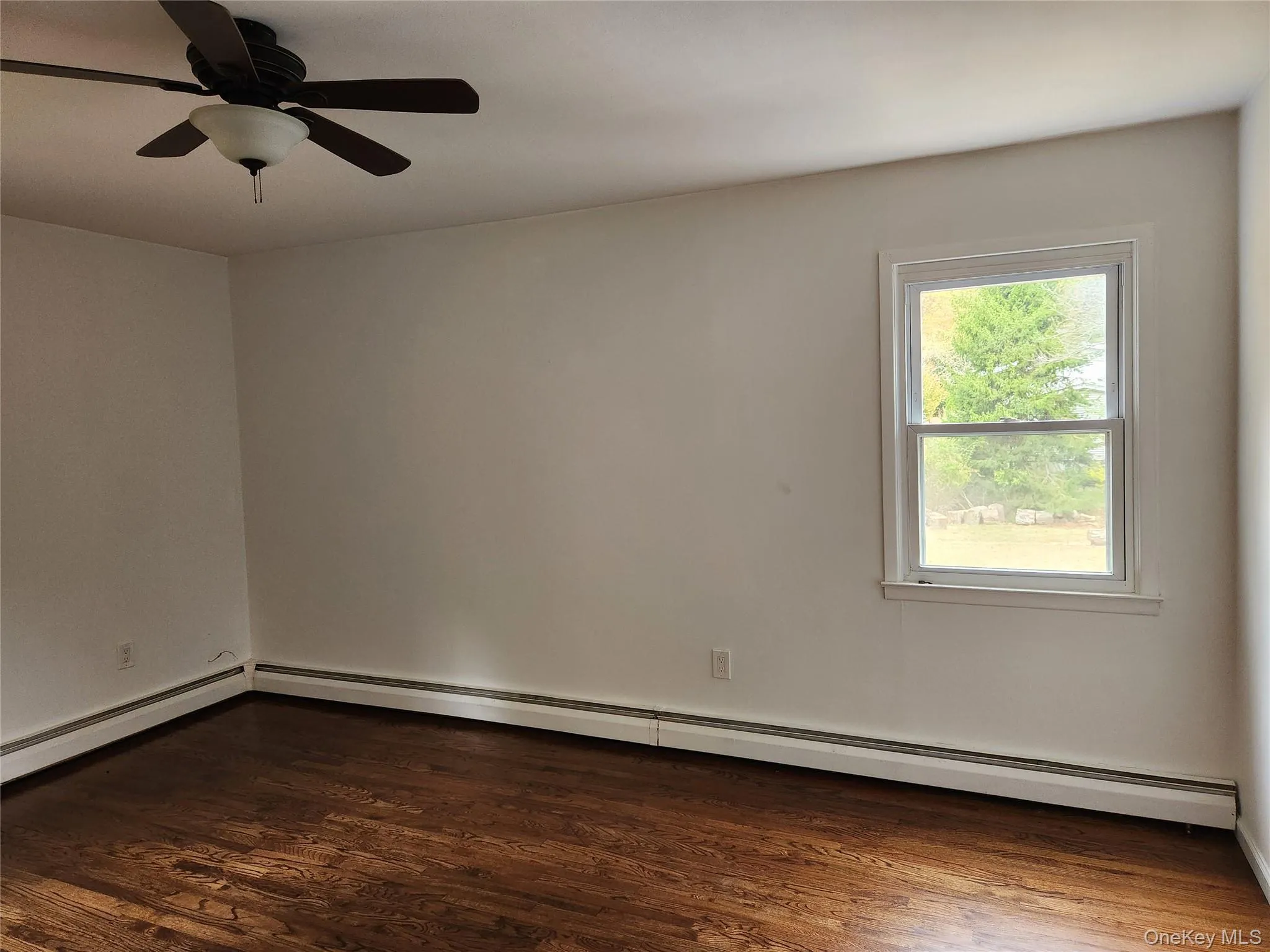Bedroom featuring a baseboard heating unit, Hard wood flooring, and ceiling fan Bedroom featuring a baseboard heating unit, Hard wood flooring, and ceiling fan