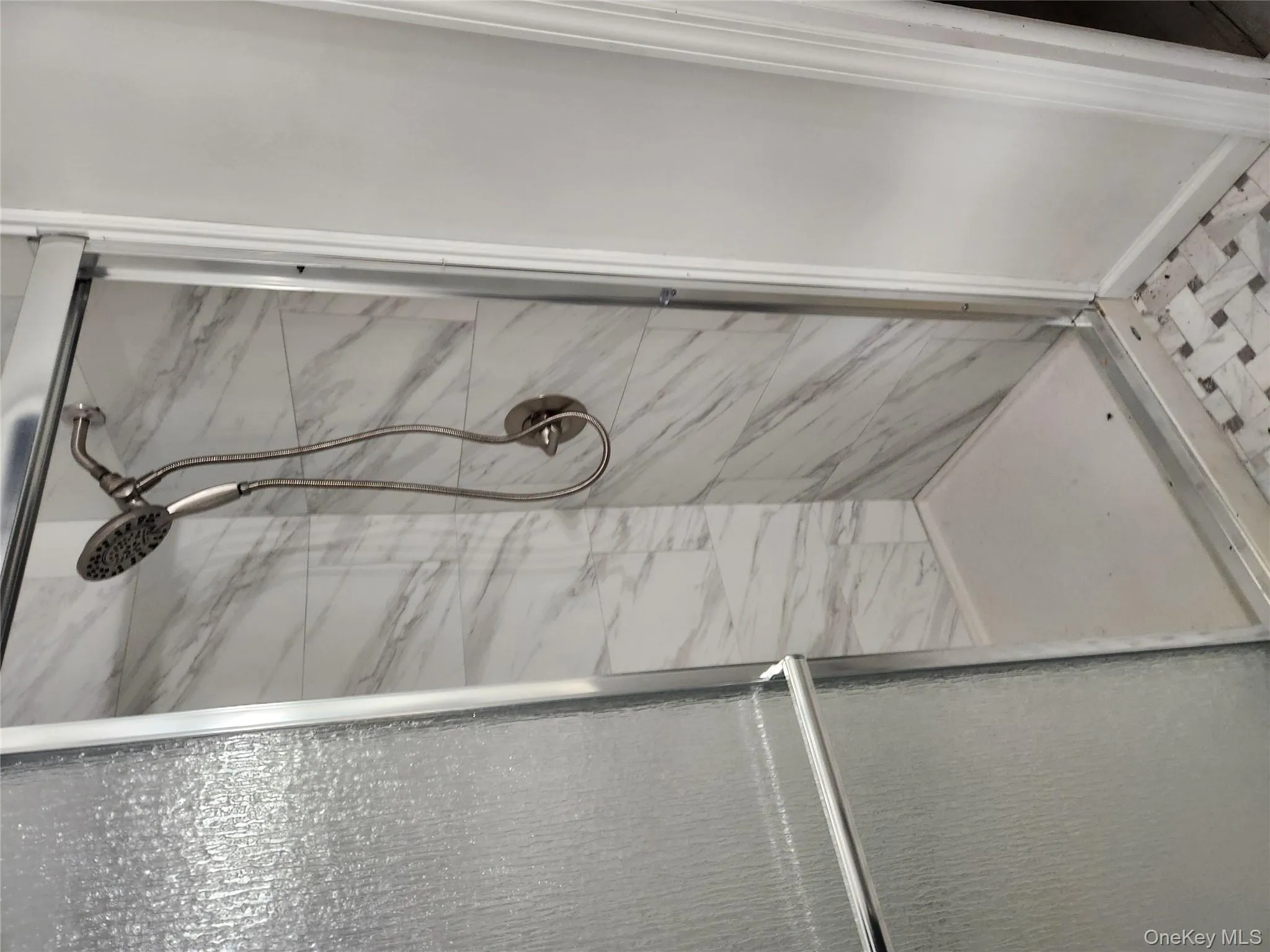 Full bath featuring a marble finish shower Full bath featuring a marble finish shower