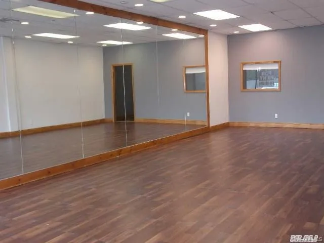 Spare room featuring a drop ceiling and dark wood-type flooring Spare room featuring a drop ceiling and dark wood-type flooring
