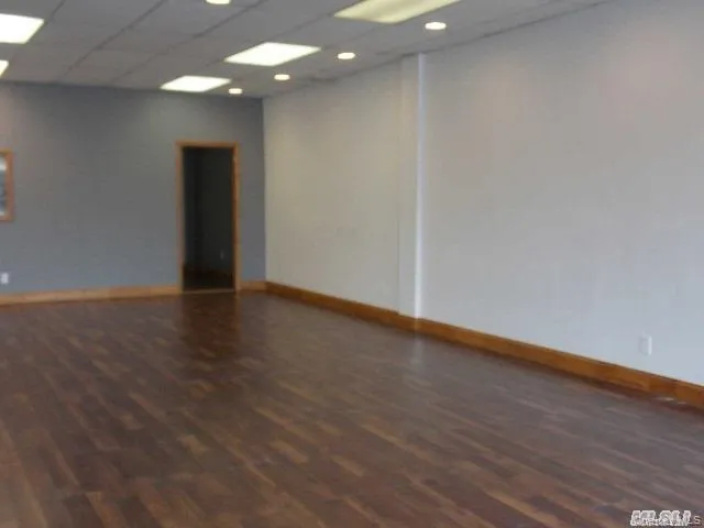 Unfurnished room with a drop ceiling, dark wood-style floors, and recessed lighting Unfurnished room with a drop ceiling, dark wood-style floors, and recessed lighting