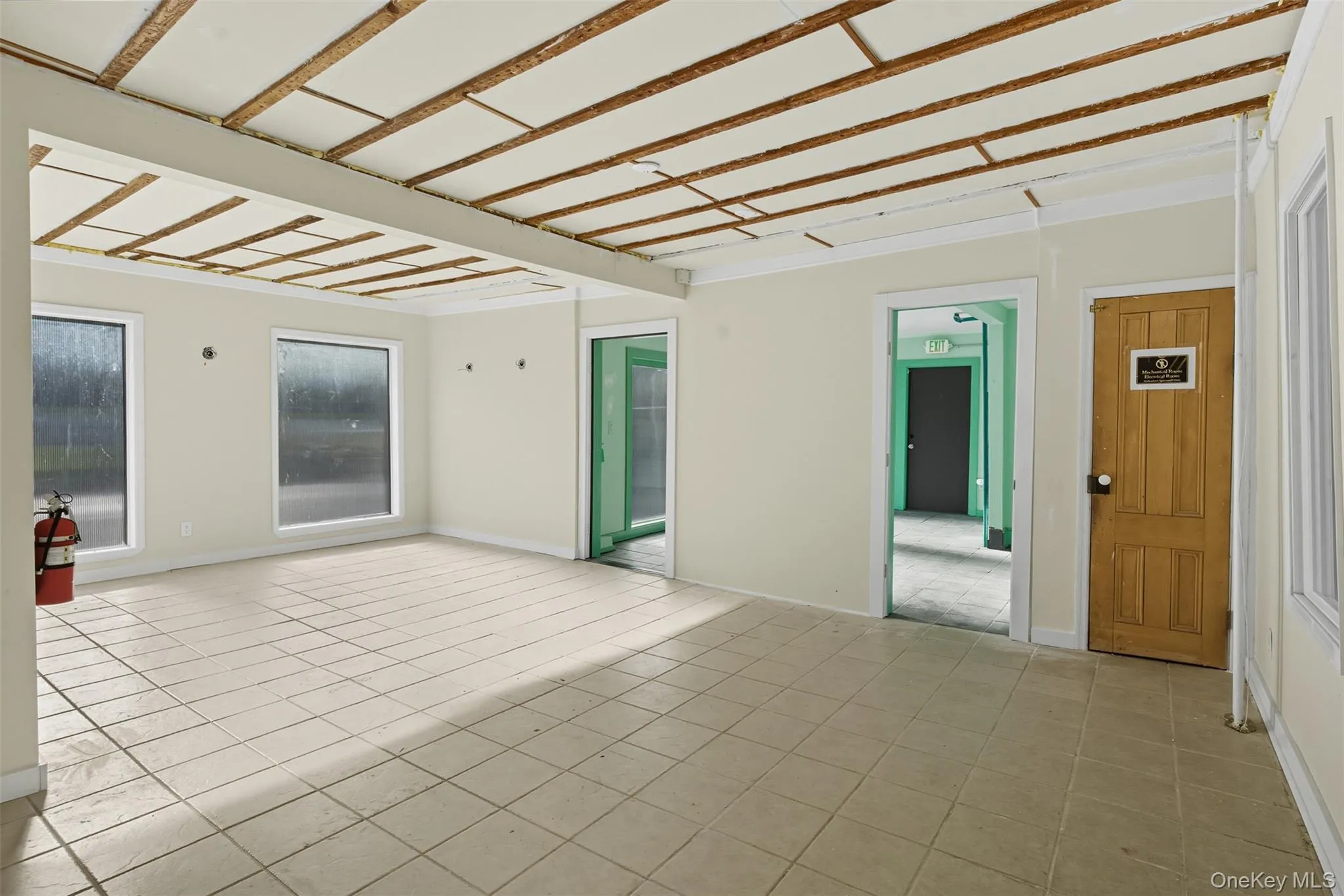 Unfurnished room with light tile patterned flooring and baseboards Unfurnished room with light tile patterned flooring and baseboards