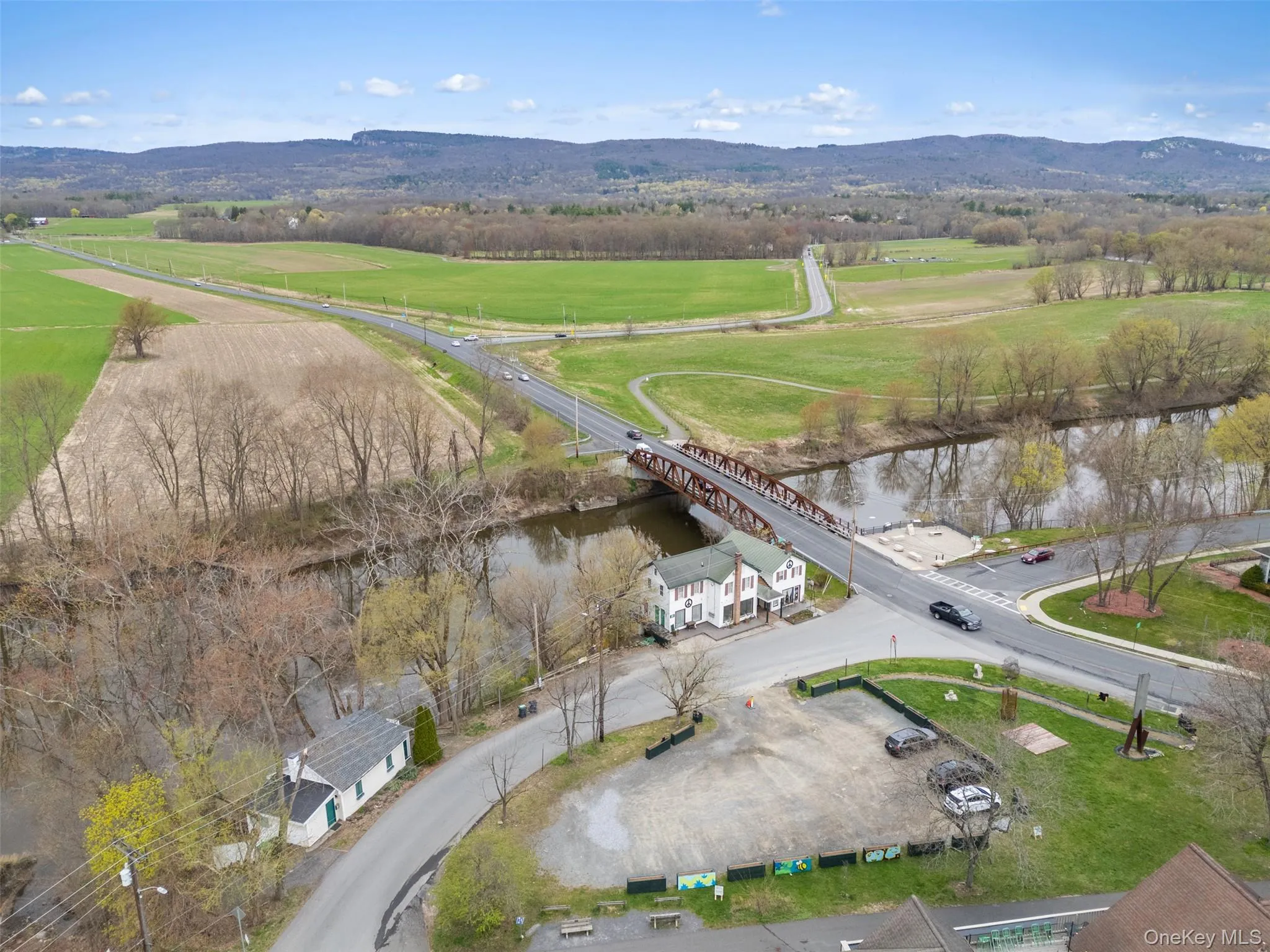 Aerial view of property and surrounding area featuring a notable bridge and a water and mountain view Aerial view of property and surrounding area featuring a notable bridge and a water and mountain view