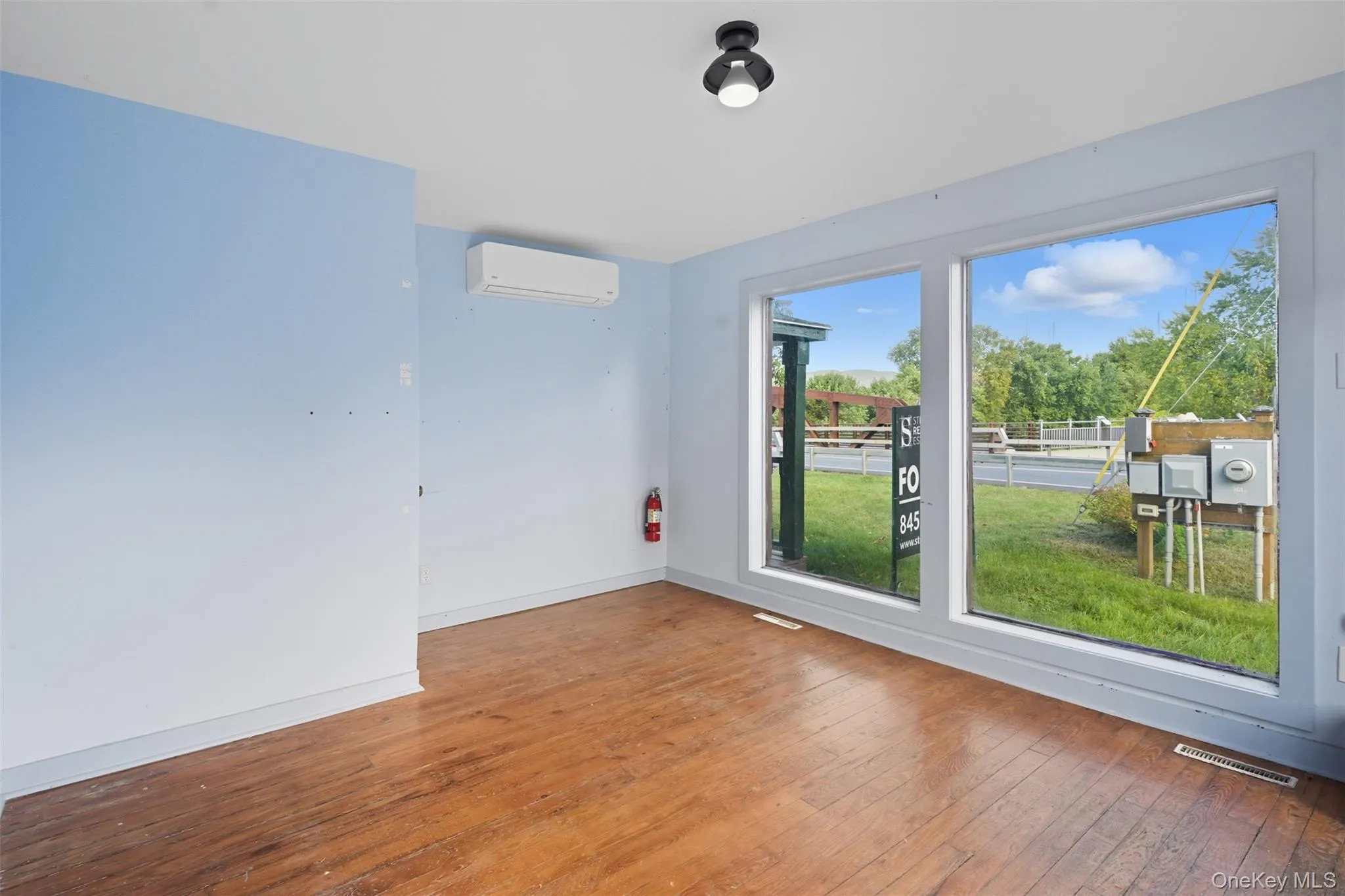 Empty room with hardwood / wood-style floors and a wall unit AC Empty room with hardwood / wood-style floors and a wall unit AC