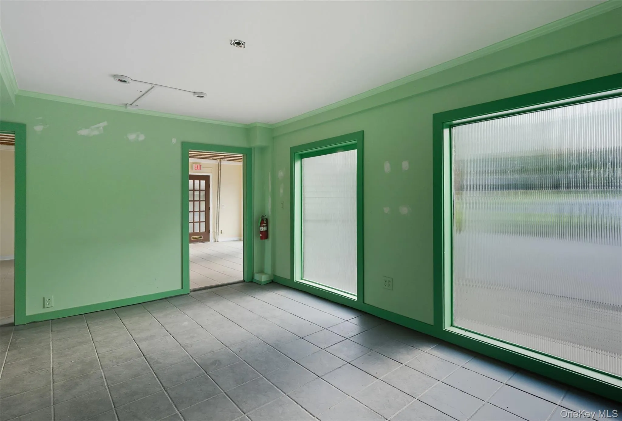 Empty room with crown molding and light tile patterned floors Empty room with crown molding and light tile patterned floors