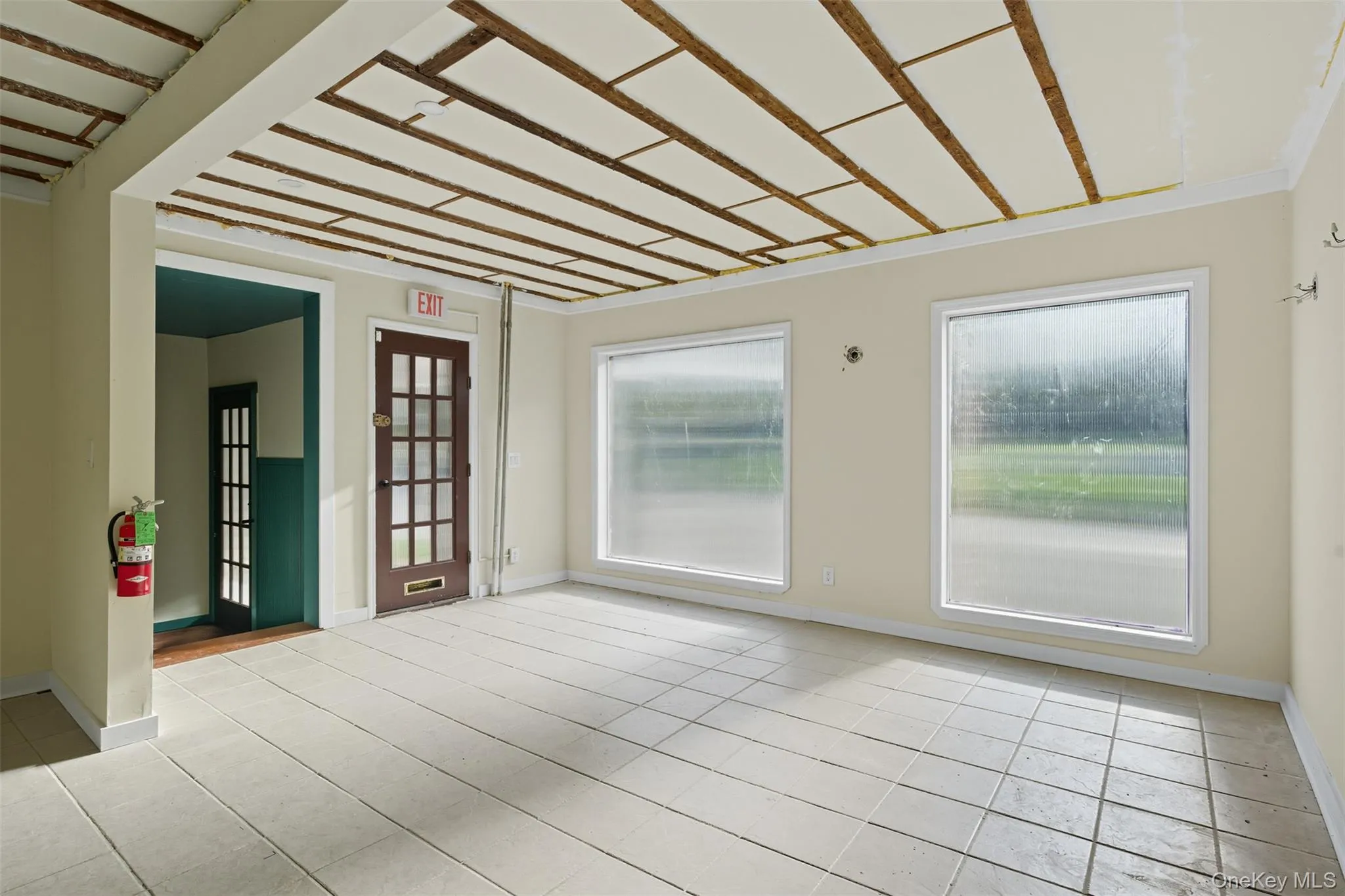 Unfurnished room with healthy amount of natural light and light tile patterned floors Unfurnished room with healthy amount of natural light and light tile patterned floors