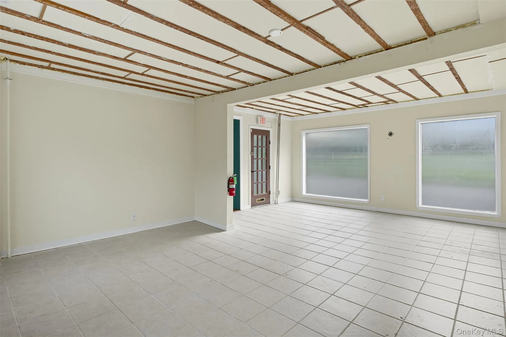 Spare room with baseboards and light tile patterned flooring Spare room with baseboards and light tile patterned flooring