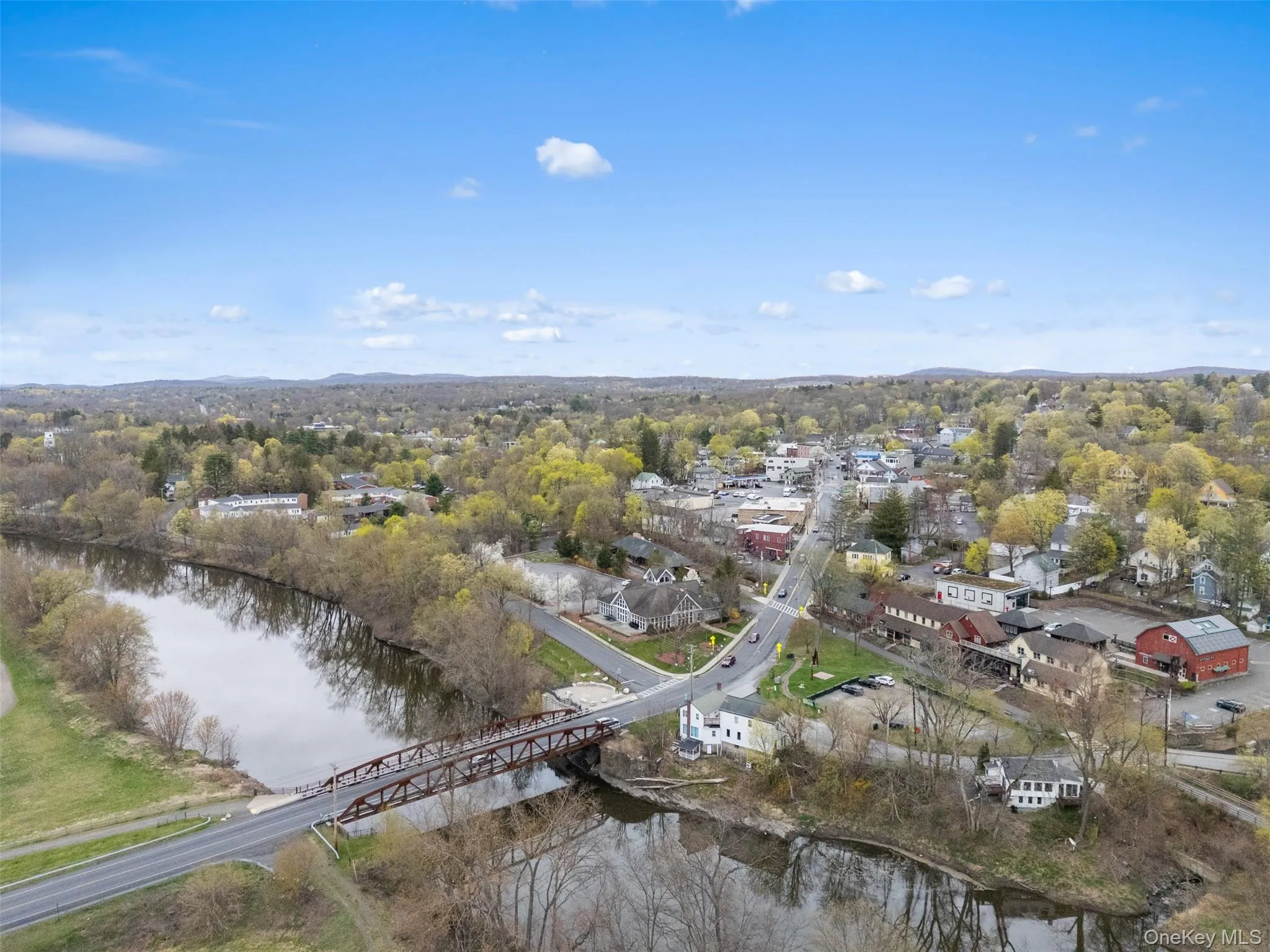 Aerial view of property and surrounding area with a nearby body of water and a notable bridge Aerial view of property and surrounding area with a nearby body of water and a notable bridge