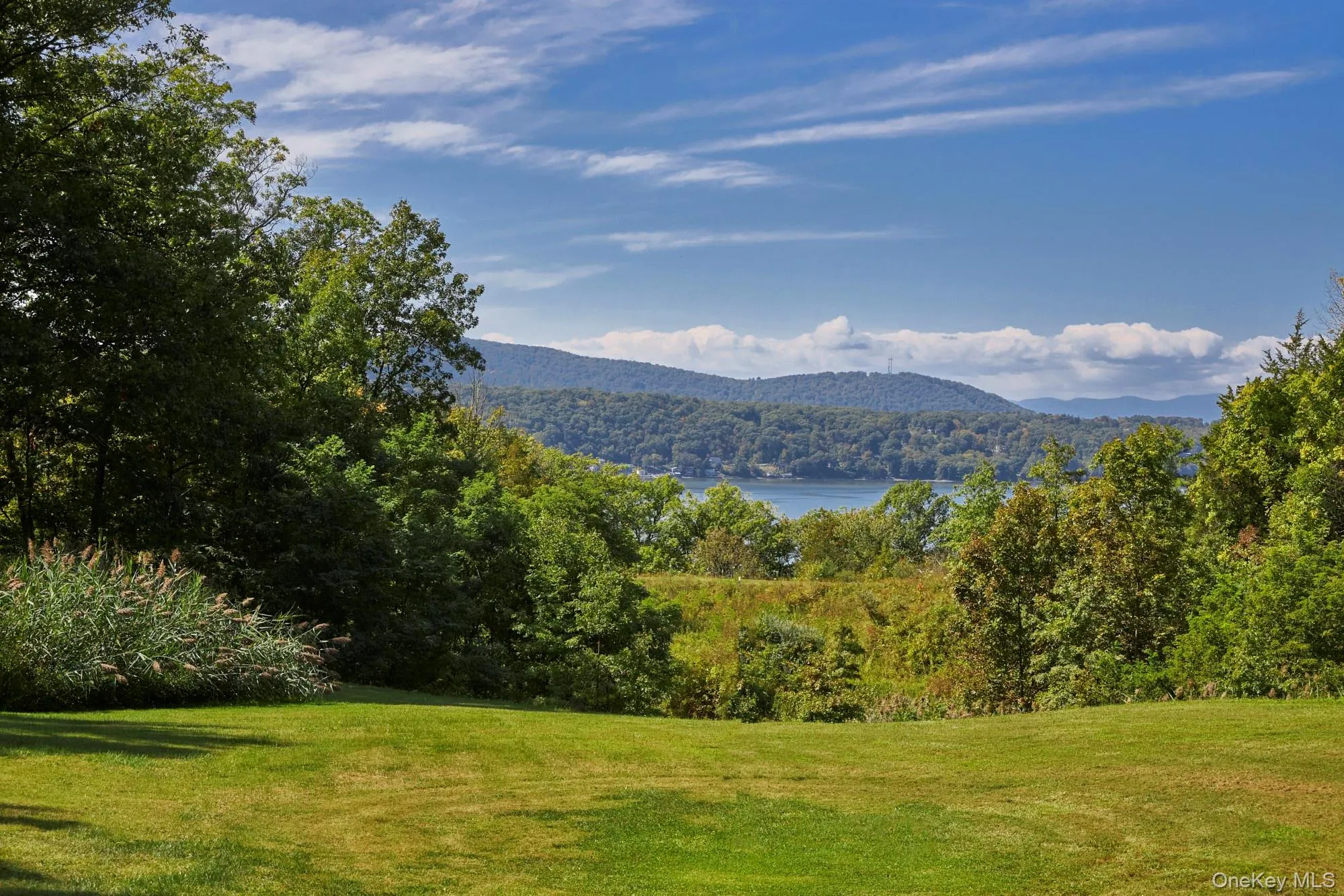 Mountain view featuring a heavily wooded area and a large body of water Mountain view featuring a heavily wooded area and a large body of water