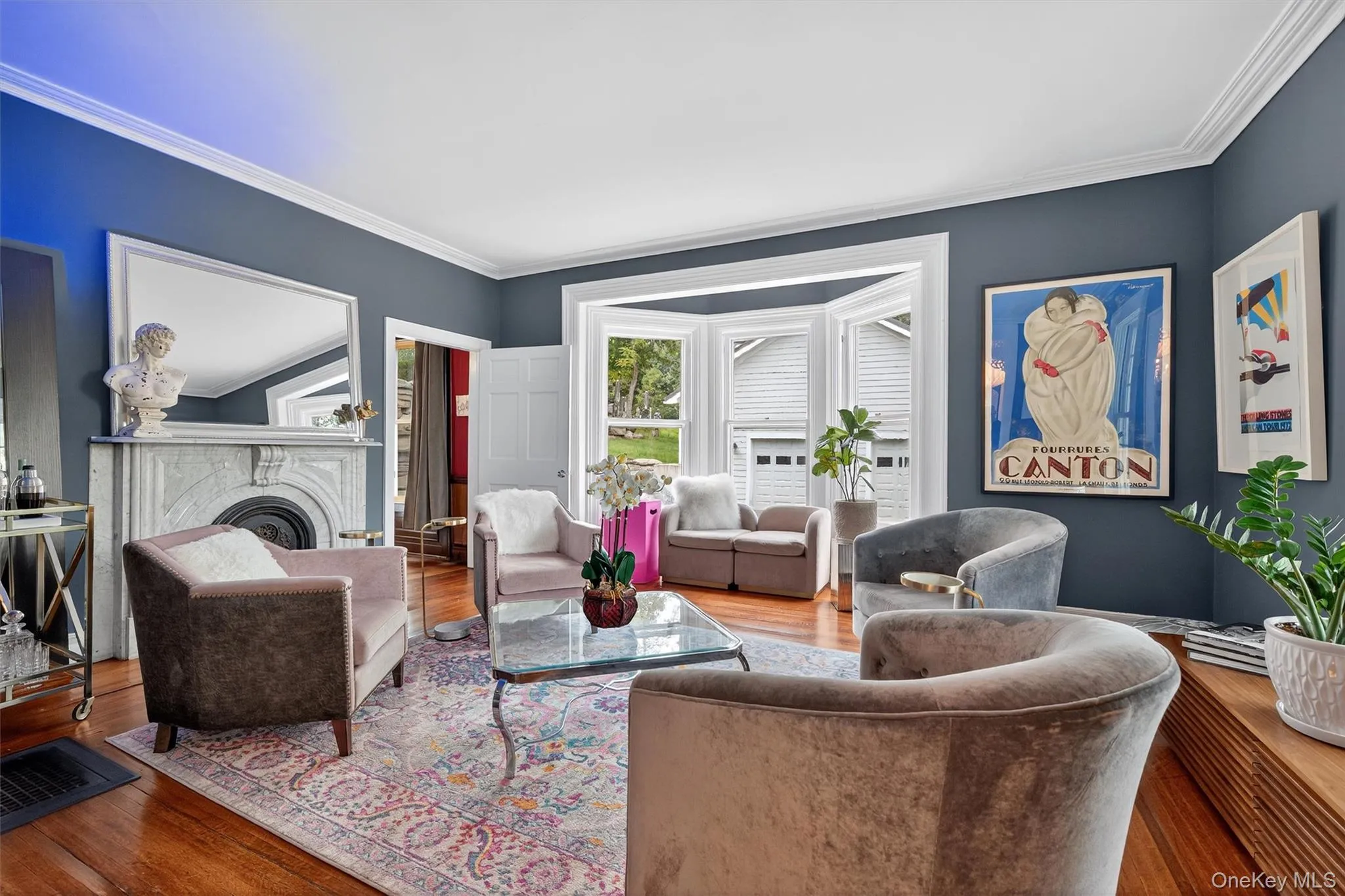 Living room featuring a fireplace, wood finished floors, and ornamental molding Living room featuring a fireplace, wood finished floors, and ornamental molding