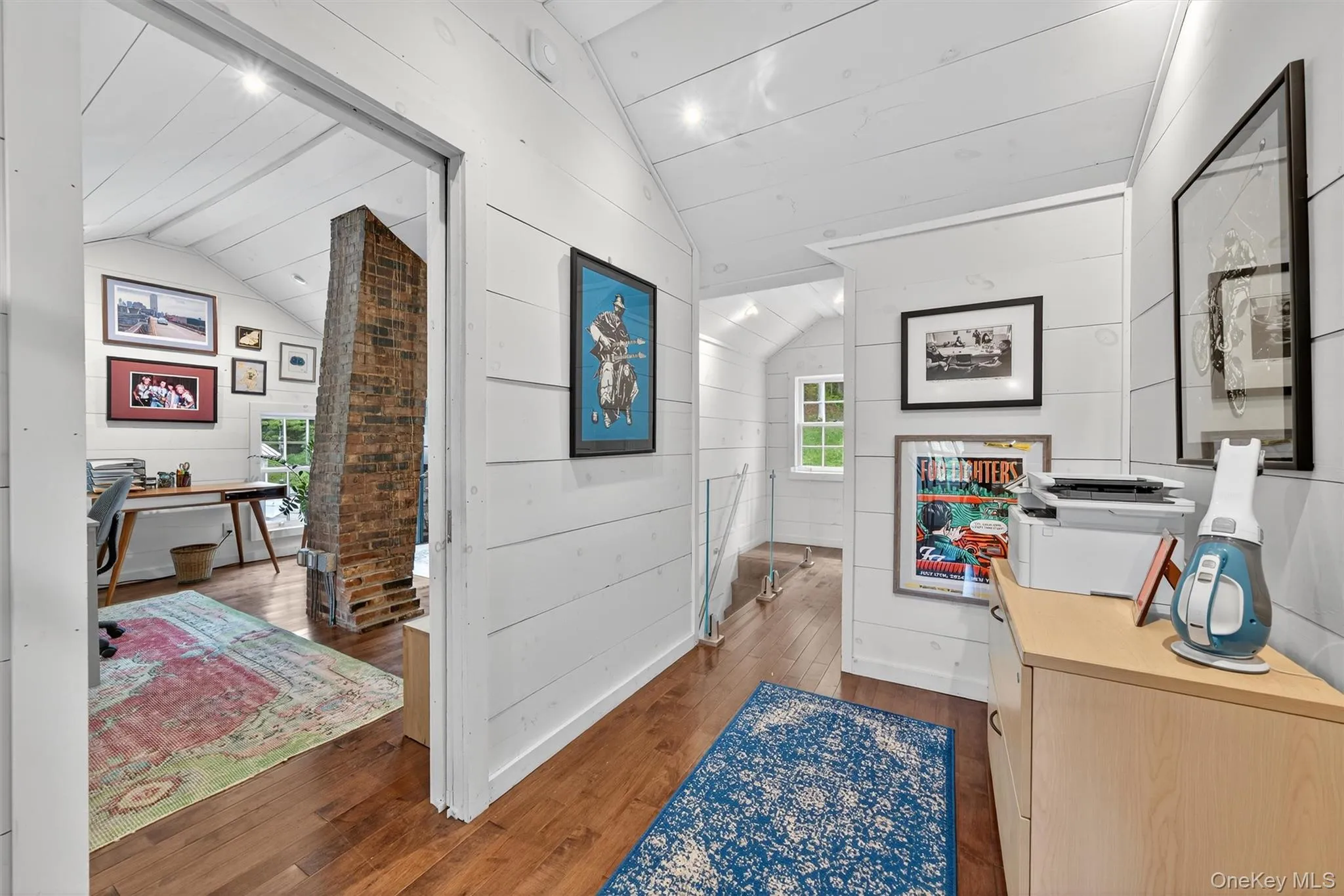 Hall featuring an office area, lofted ceiling, and wood-type flooring Hall featuring an office area, lofted ceiling, and wood-type flooring