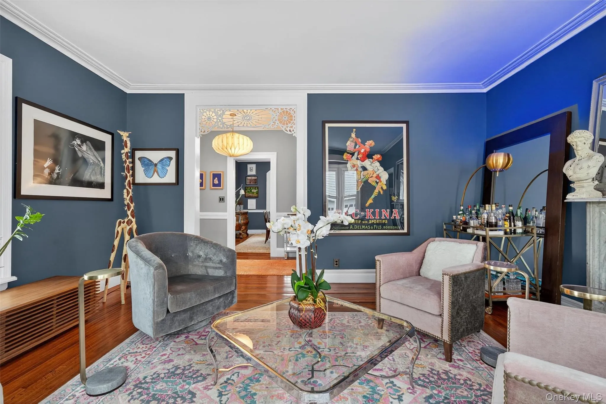 Living area featuring wood finished floors and ornamental molding Living area featuring wood finished floors and ornamental molding