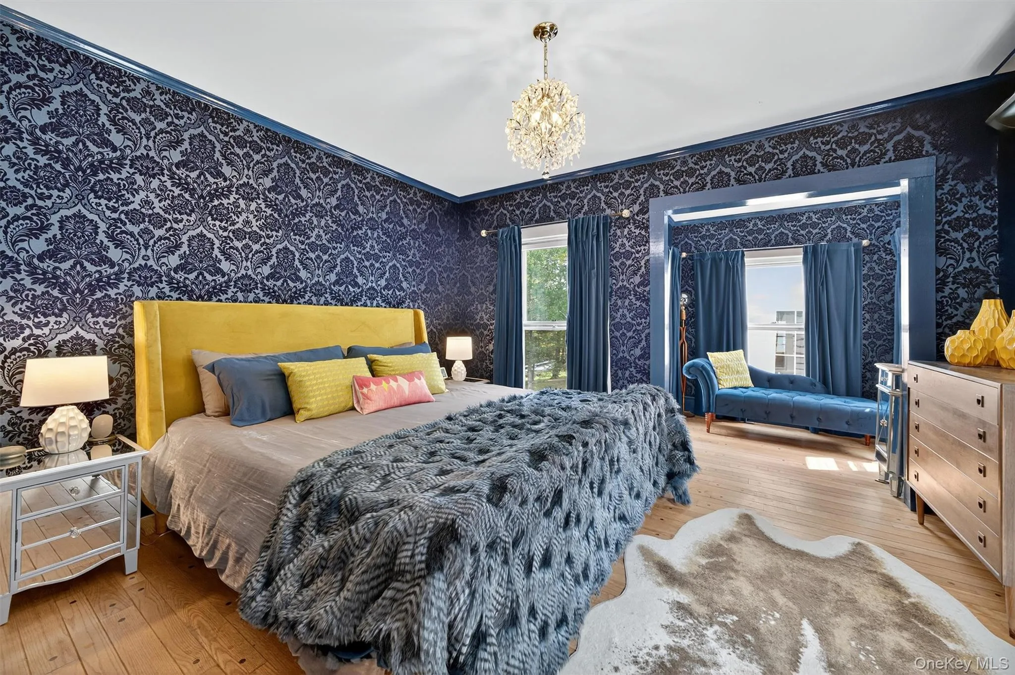 Bedroom with hardwood / wood-style floors, ornamental molding, wallpapered walls, and a chandelier Bedroom with hardwood / wood-style floors, ornamental molding, wallpapered walls, and a chandelier
