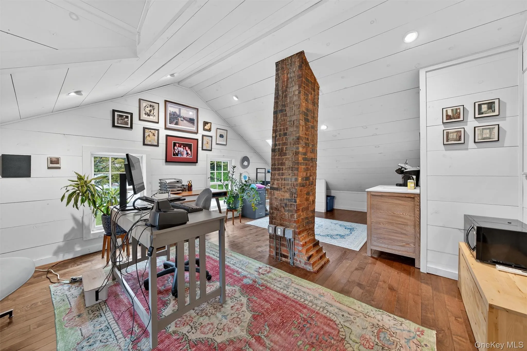 Office space with hardwood / wood-style floors, vaulted ceiling, wood walls, and recessed lighting Office space with hardwood / wood-style floors, vaulted ceiling, wood walls, and recessed lighting