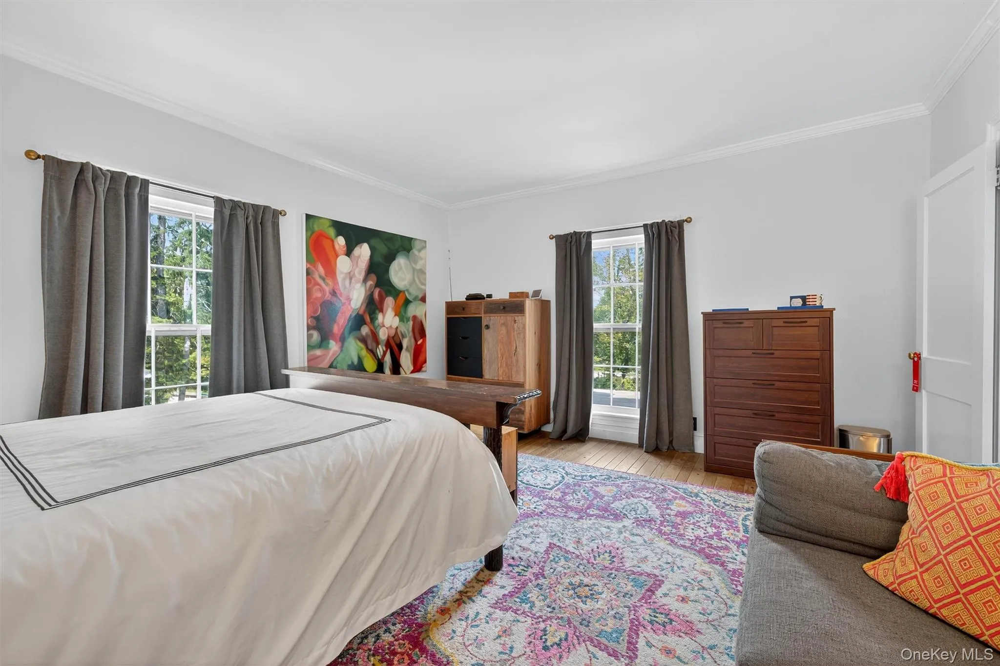 Bedroom featuring crown molding and wood finished floors Bedroom featuring crown molding and wood finished floors