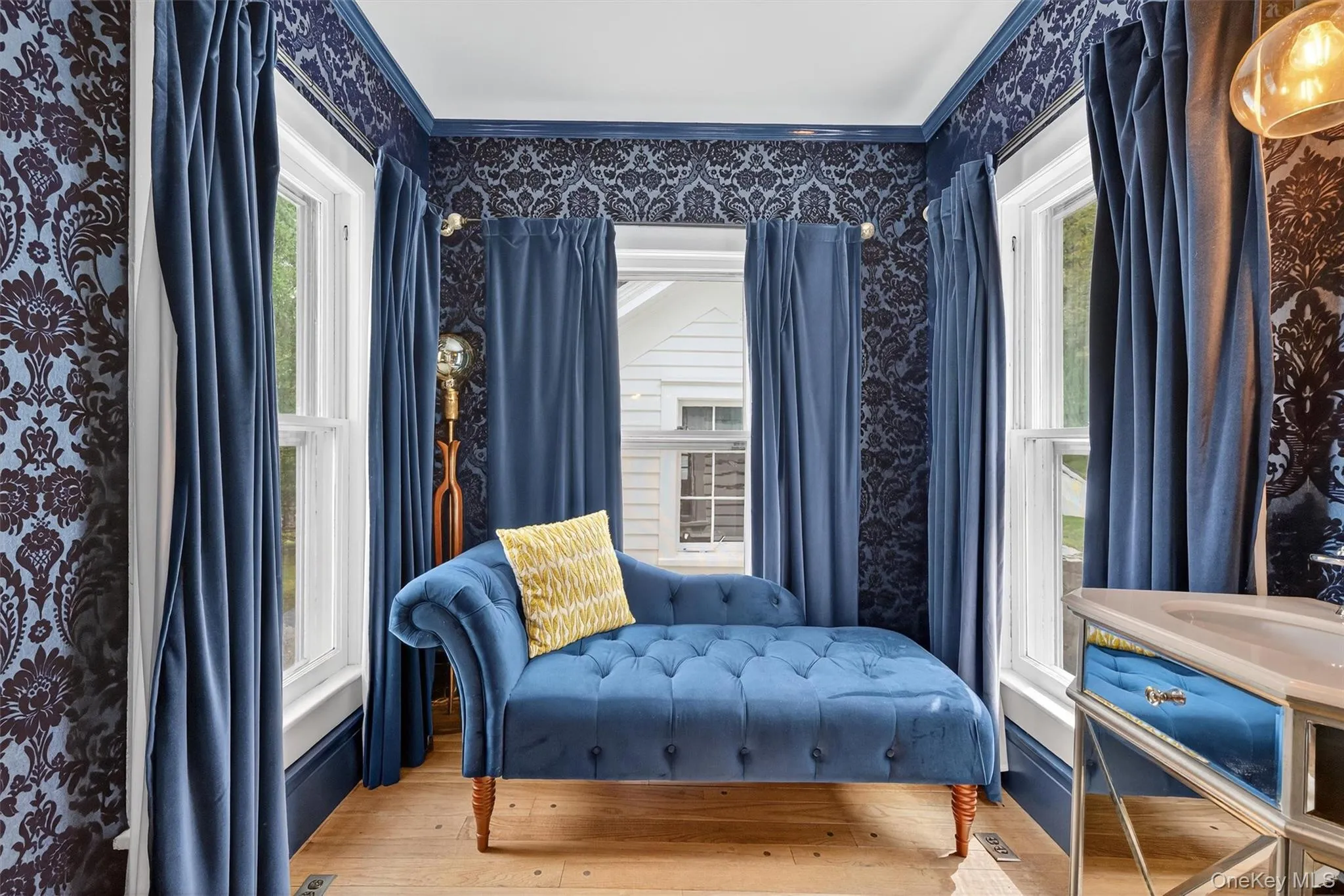 Sitting room featuring hardwood / wood-style floors and wallpapered walls Sitting room featuring hardwood / wood-style floors and wallpapered walls