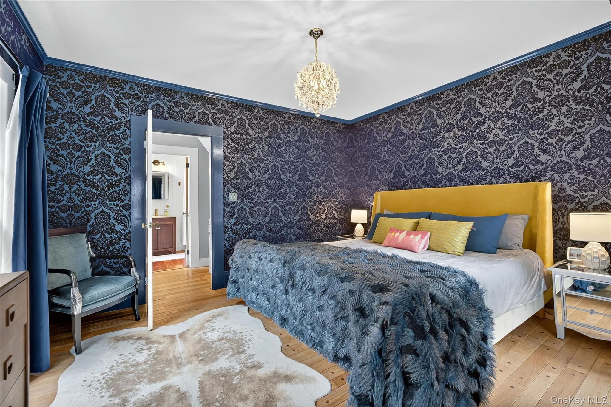 Bedroom with hardwood / wood-style flooring, a chandelier, wallpapered walls, crown molding, and ensuite bathroom Bedroom with hardwood / wood-style flooring, a chandelier, wallpapered walls, crown molding, and ensuite bathroom