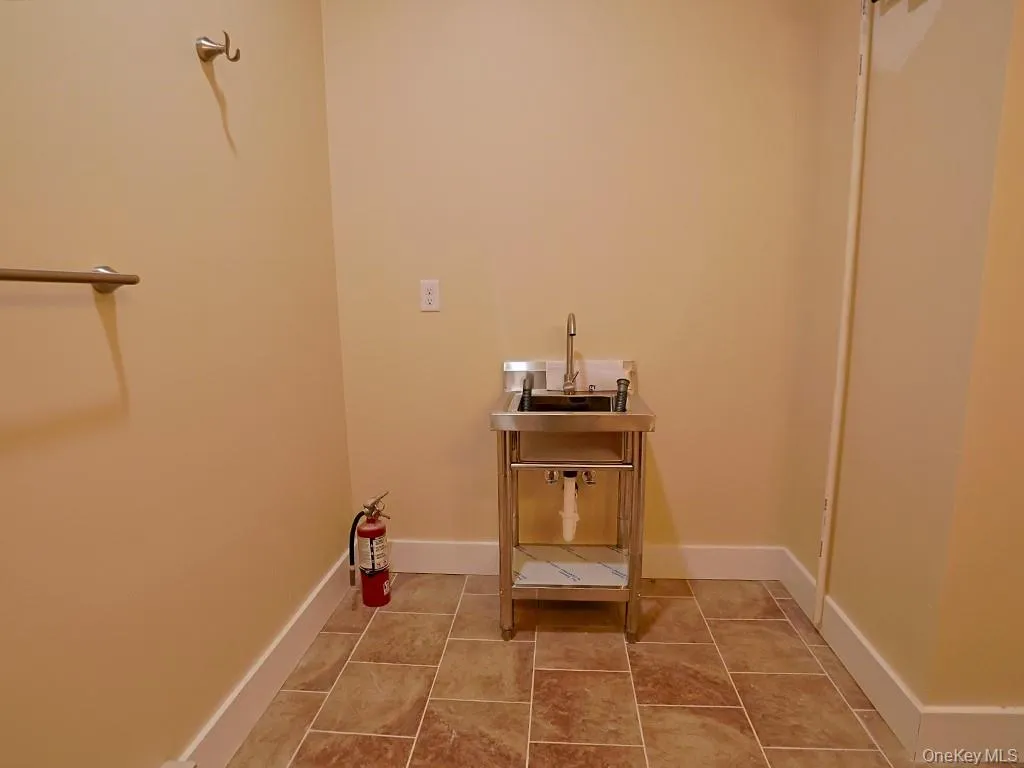 Laundry area featuring light tile patterned floors and baseboards Laundry area featuring light tile patterned floors and baseboards
