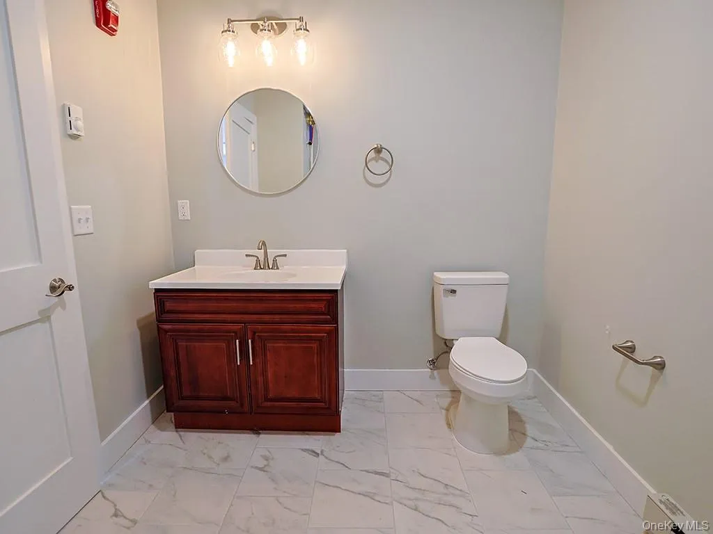 Half bathroom with vanity and light marble finish flooring Half bathroom with vanity and light marble finish flooring
