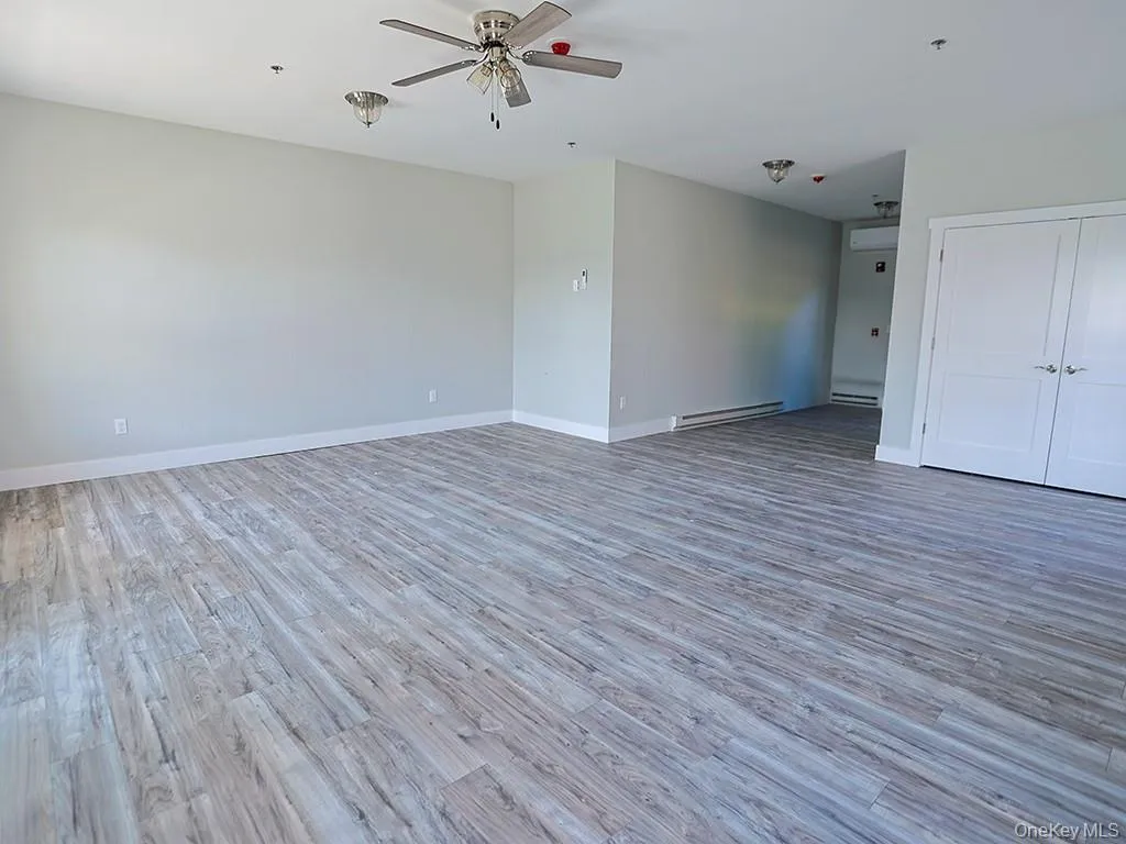 Spare room with light wood-type flooring, a baseboard heating unit, and ceiling fan Spare room with light wood-type flooring, a baseboard heating unit, and ceiling fan